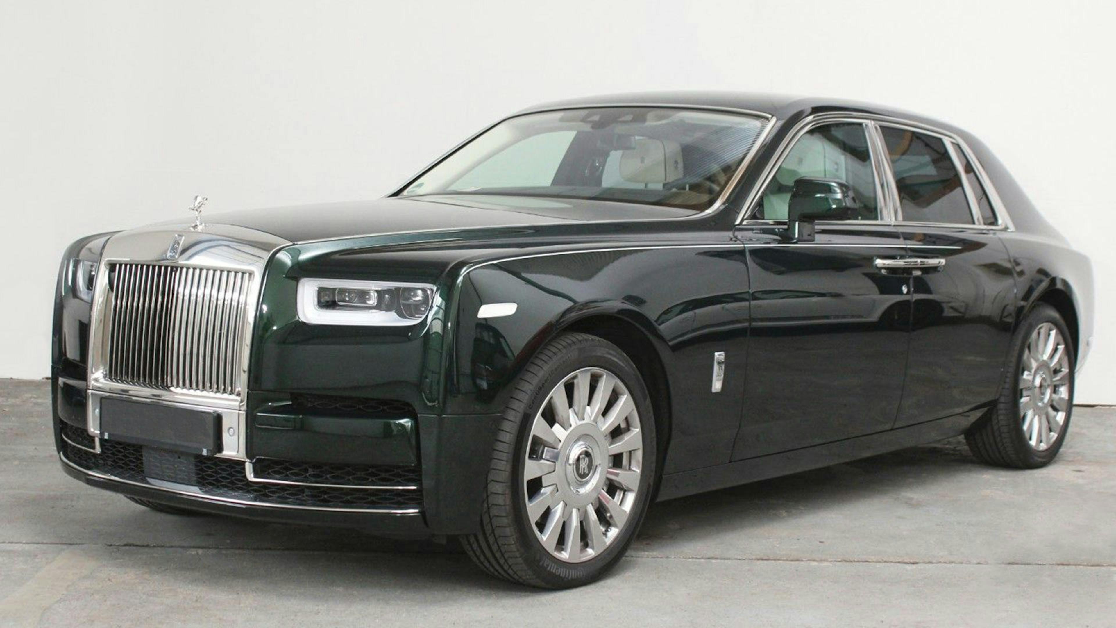 Ein schwarzer Rolls-Royce Phantom steht vor einer weißen Wand.