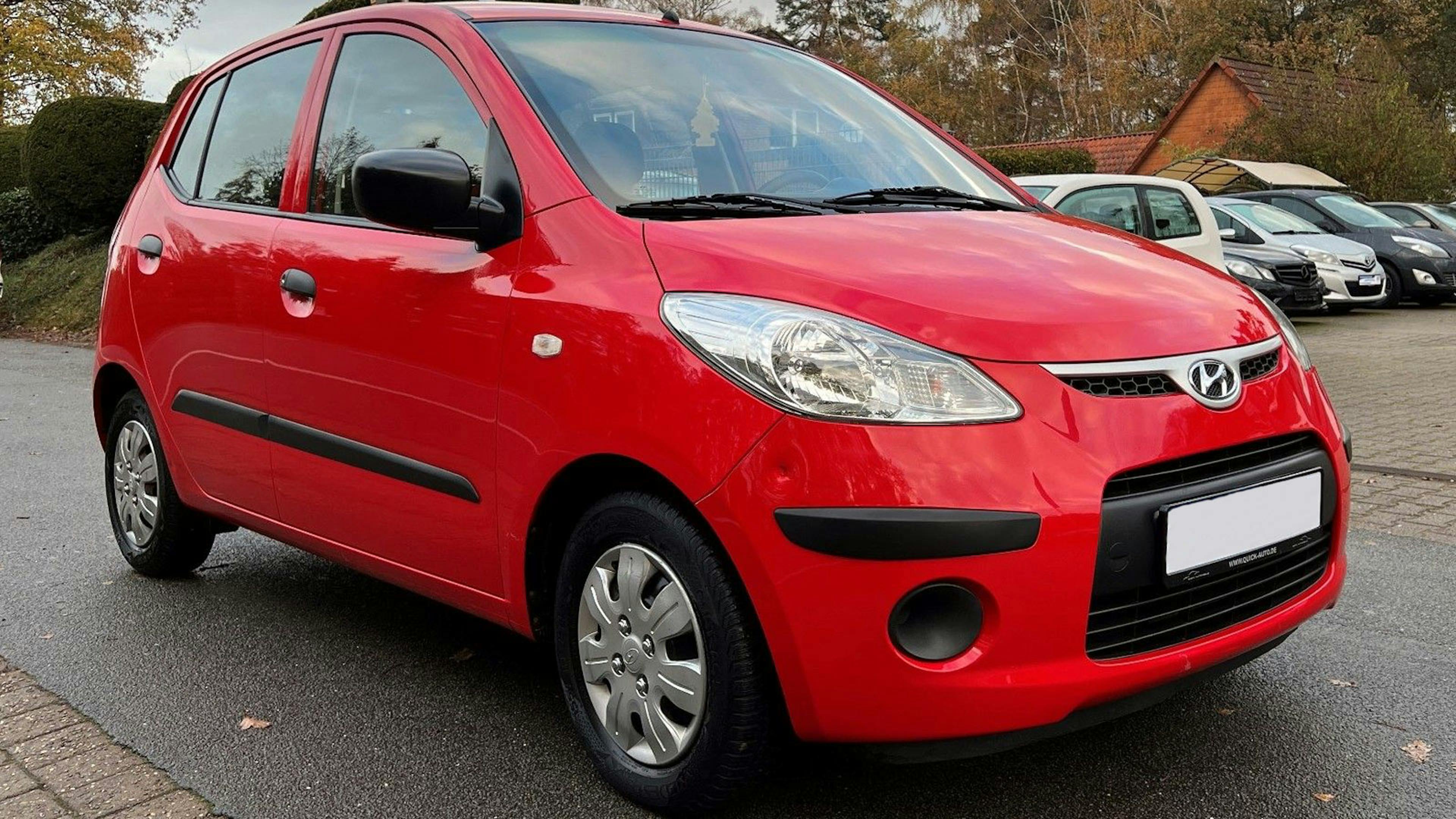 Ein roter Hyundai i10 Kleinstwagen steht auf einem Parkplatz.