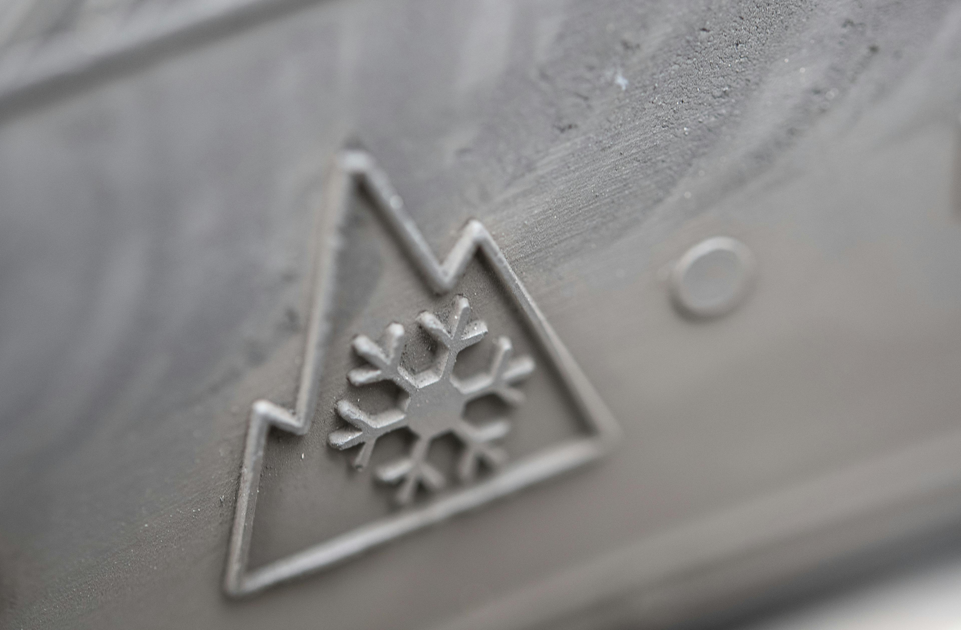 Nahaufnahme eines Reifens mit Schneeflockensymbol in einem Berg, das für Wintertauglichkeit steht.