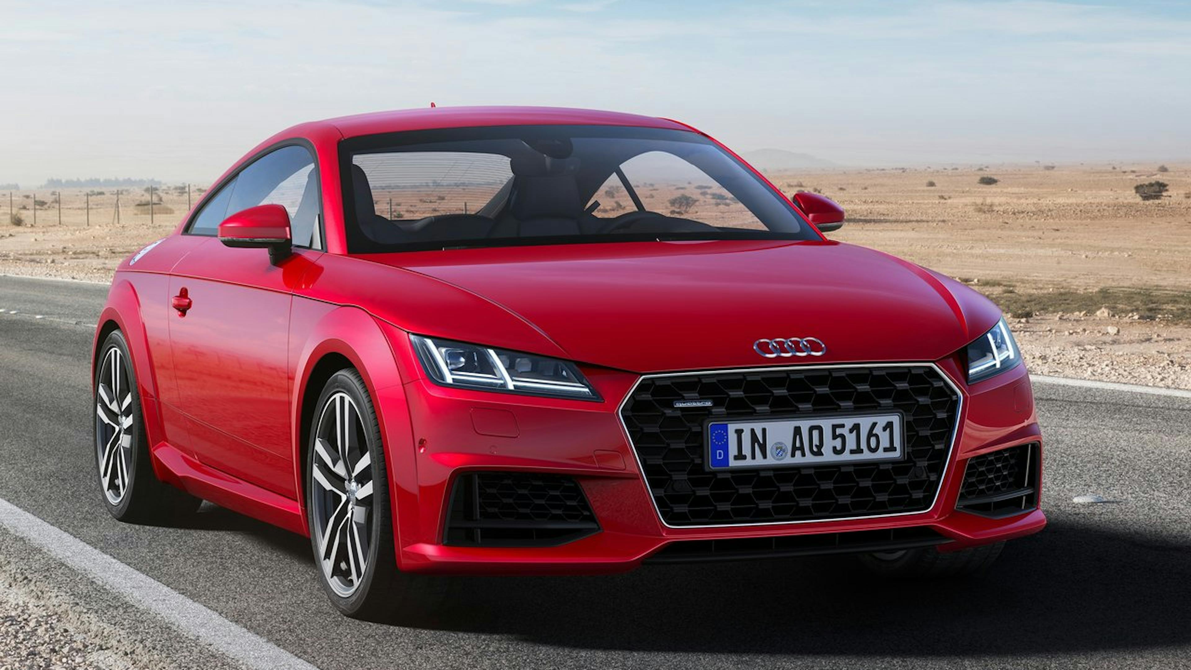 A red Audi TT is parked on a country road.