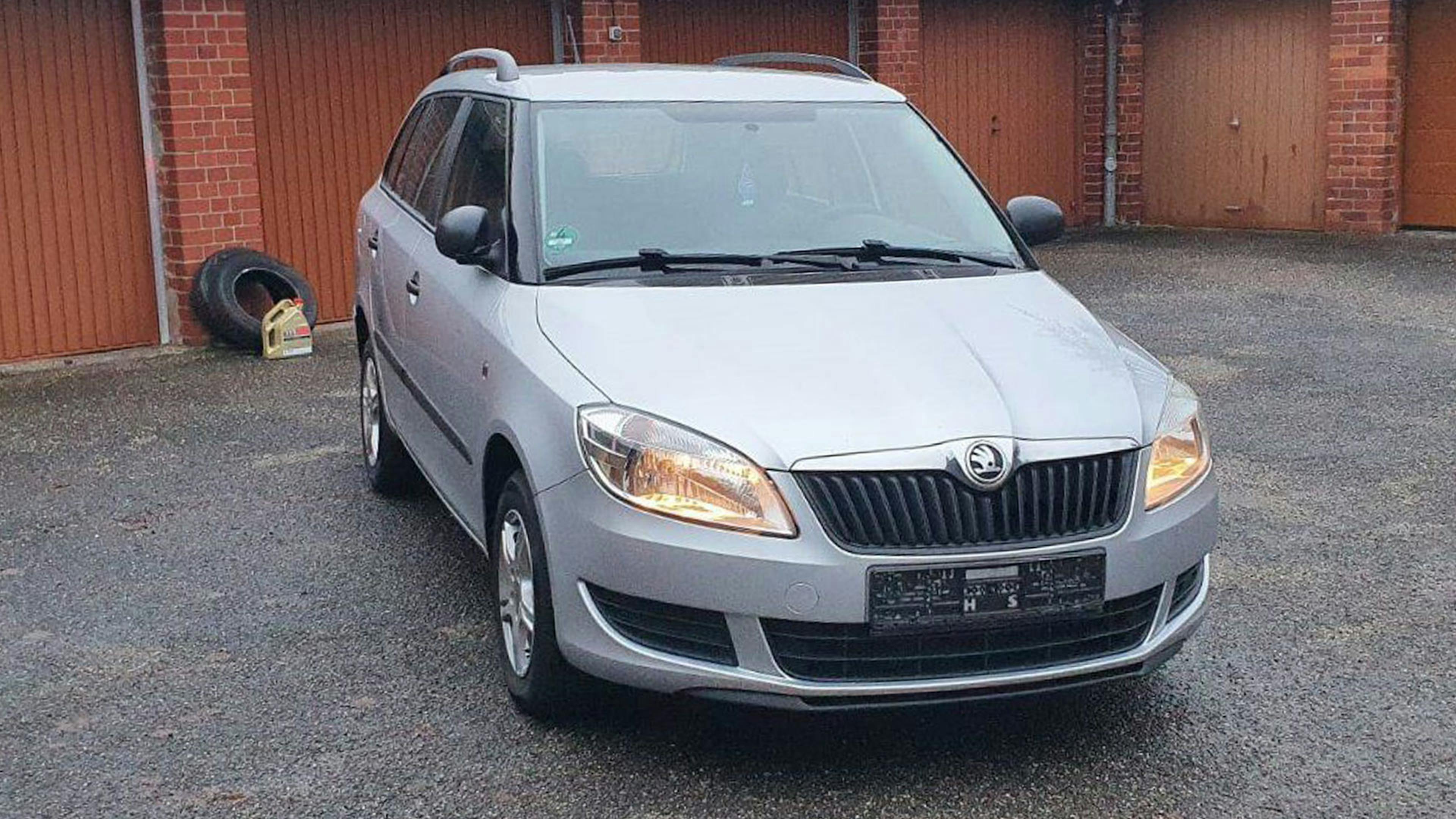 Ein silberner Škoda Fabia Combi II steht vor einer Garagenfront.