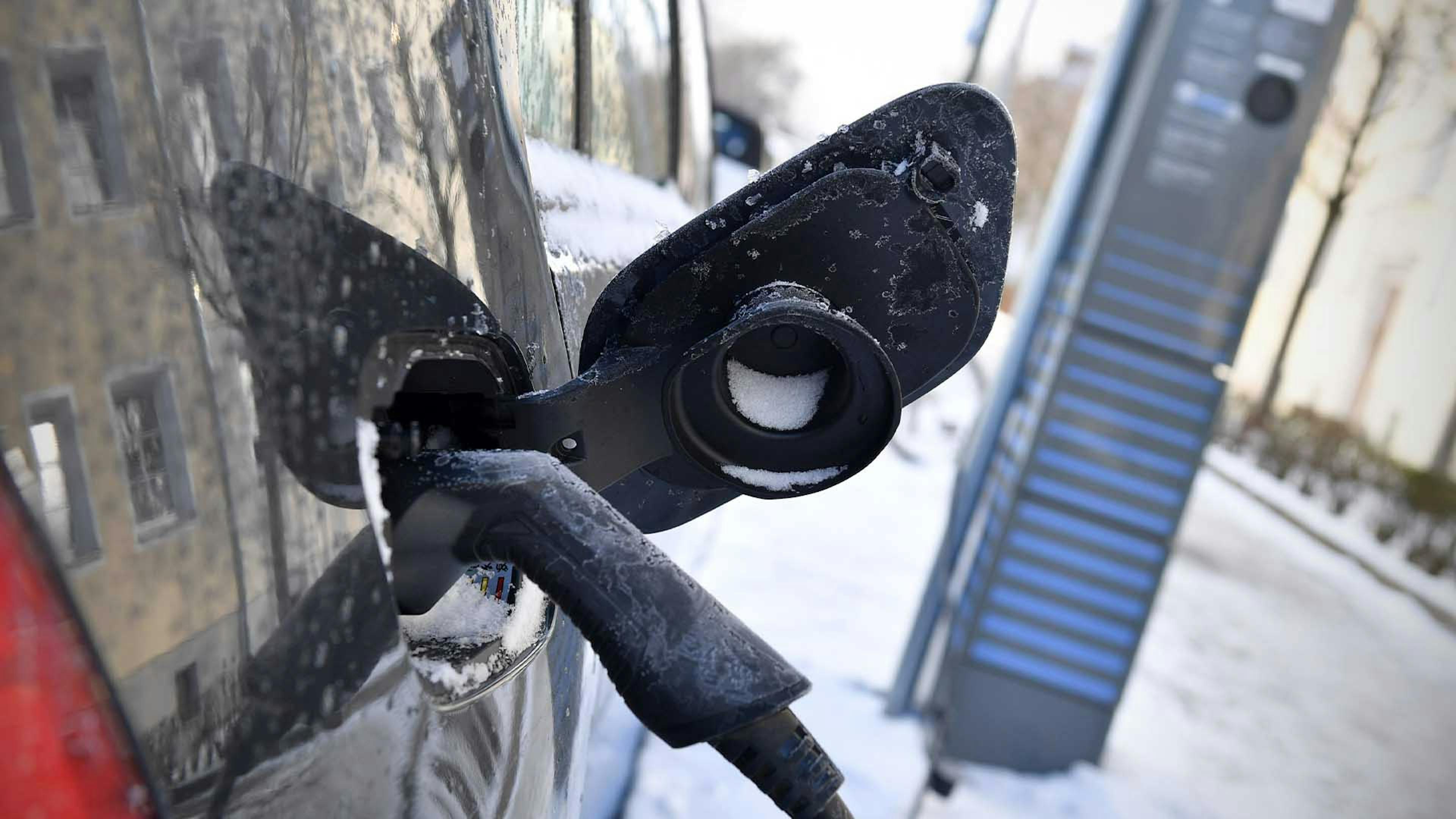 Ein Elektroauto wird im Winter aufgeladen.