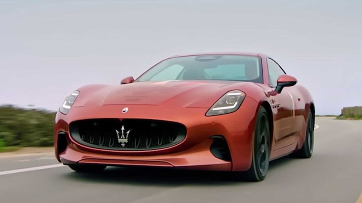 Ein rotes Maserati GranTurismo Folgore Elektroauto fährt eine Landstraße entlang.