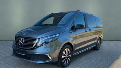 Ein grauer Mercedes-Benz EQV steht vor einer grauen Wand