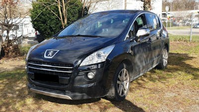 Ein schwarzer Peugeot 3008 Diesel-Hybrid steht auf einer Wiese