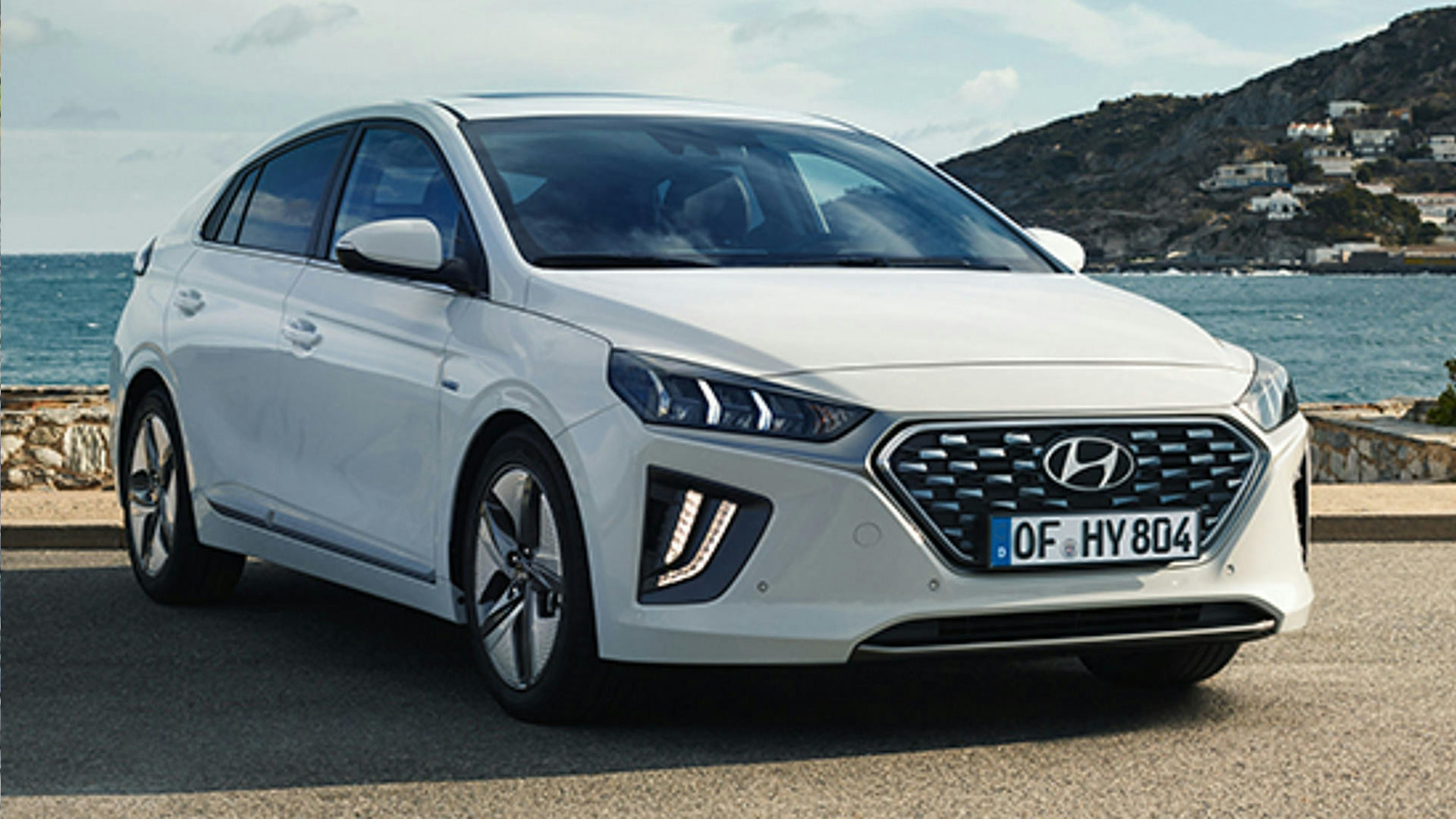 Ein weißer Hyundai Ioniq Hybrid steht an einem Gewässer.