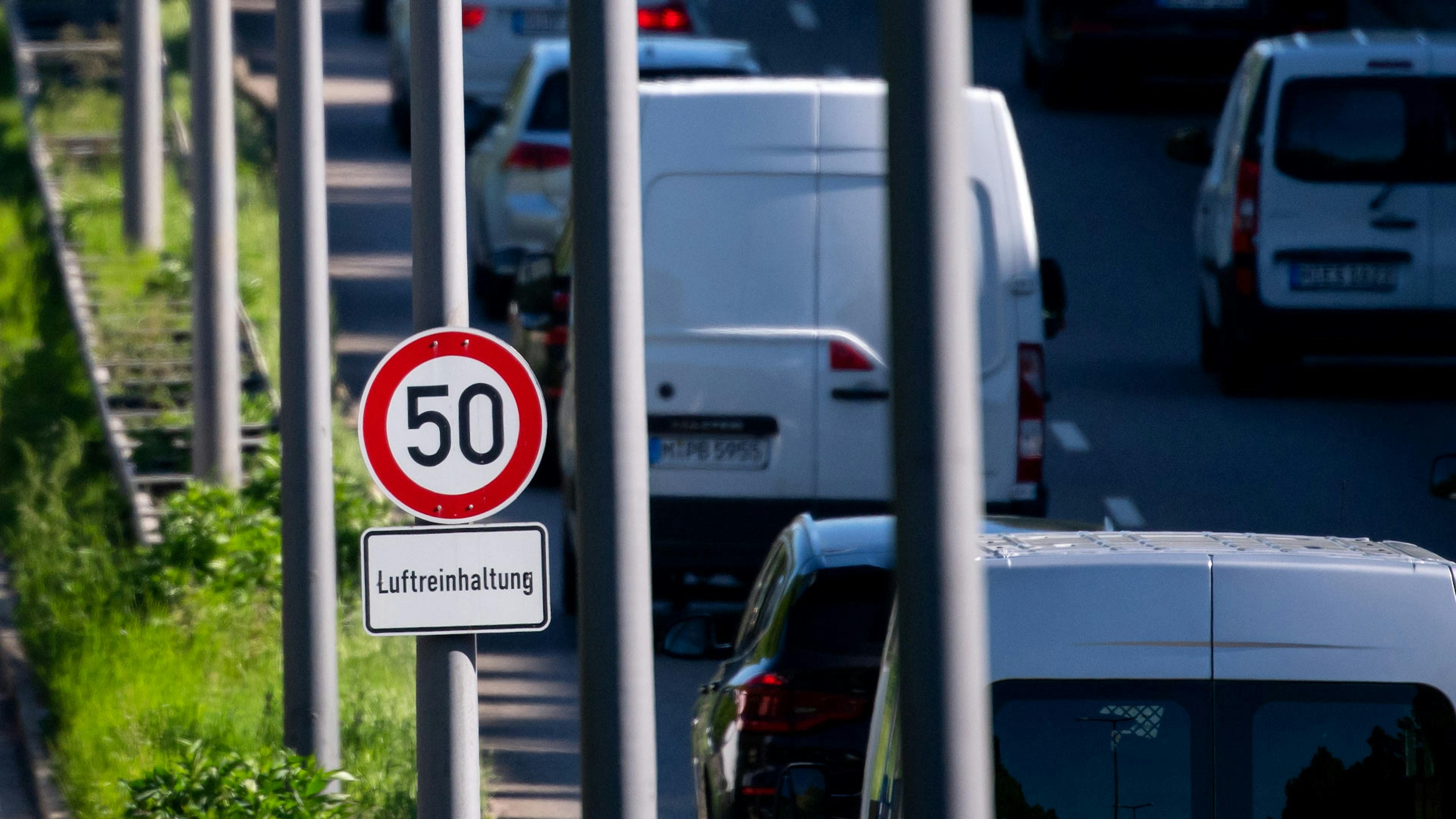 Ein Tempolimitschild steht an einer viel befahrenen Straße.