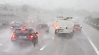 Mehrere Autos fahren auf einer Autobahn im Regen, auf der es zu Aquaplaning kommen kann.