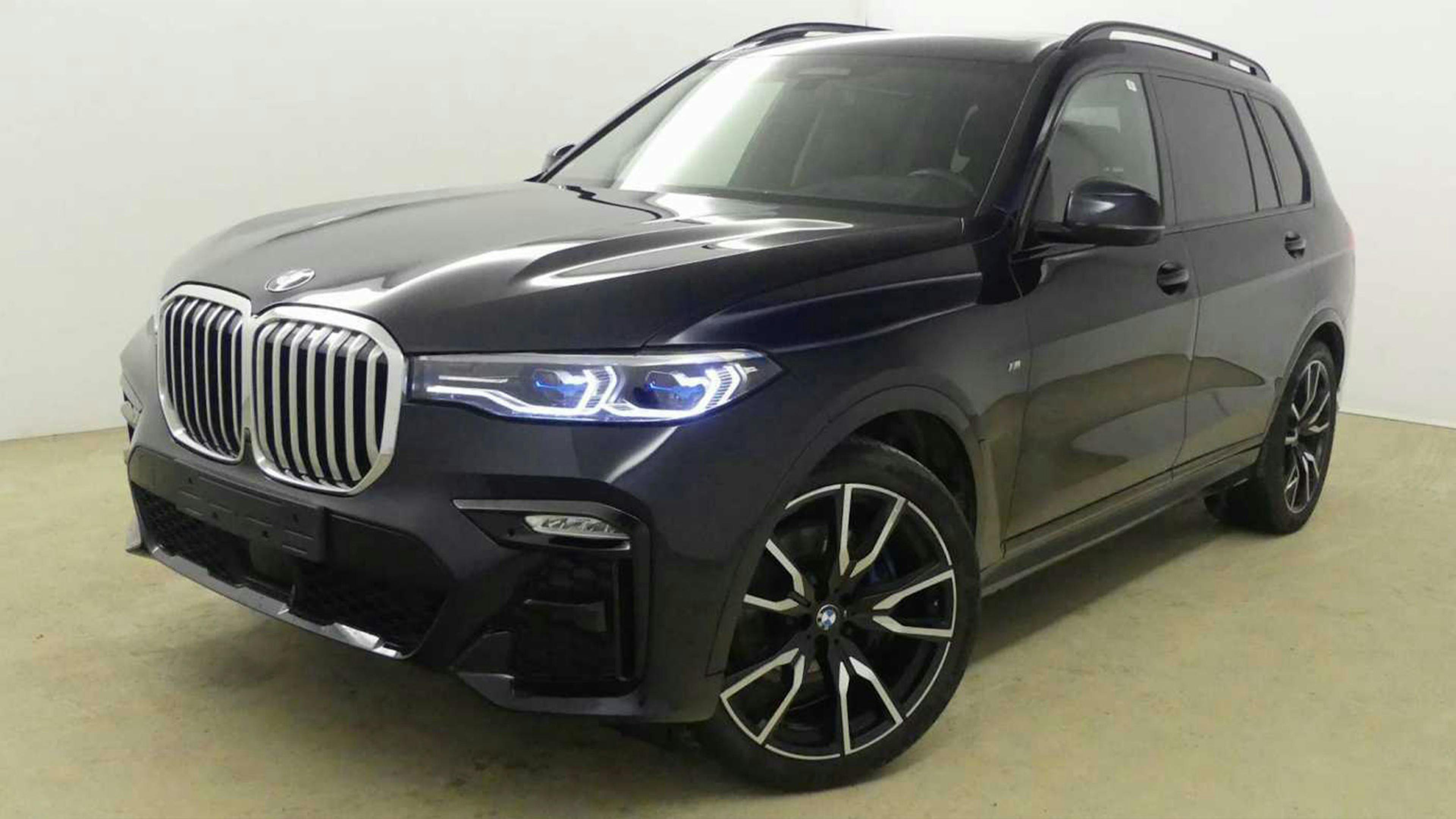 Ein schwarzer BMW X7 xDrive 30d steht vor einer weißen Wand.