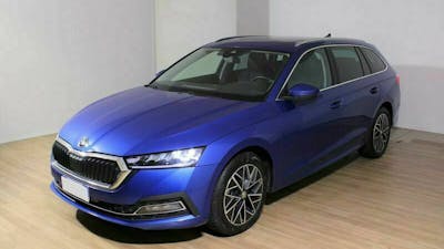 Ein blauer Škoda Octavia Combi 1.5 G-Tec steht in einem Raum mit weißen Wänden und hellem Holzfußboden.