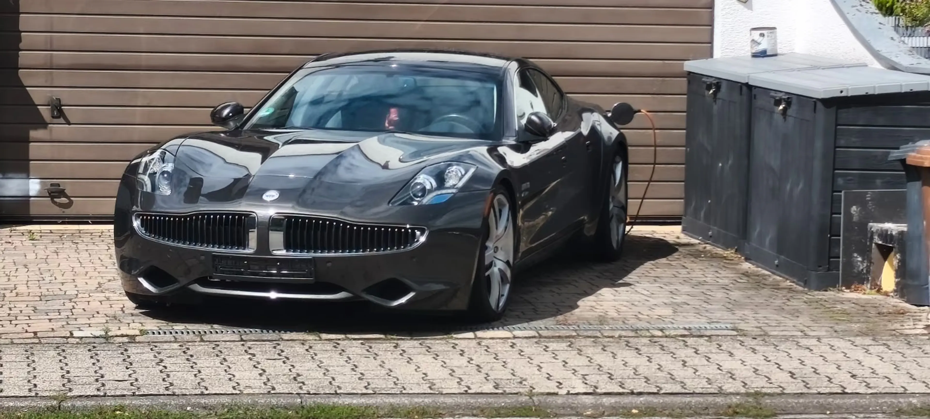 Schwarzer Fisker Karma steht in Einfahrt und lädt