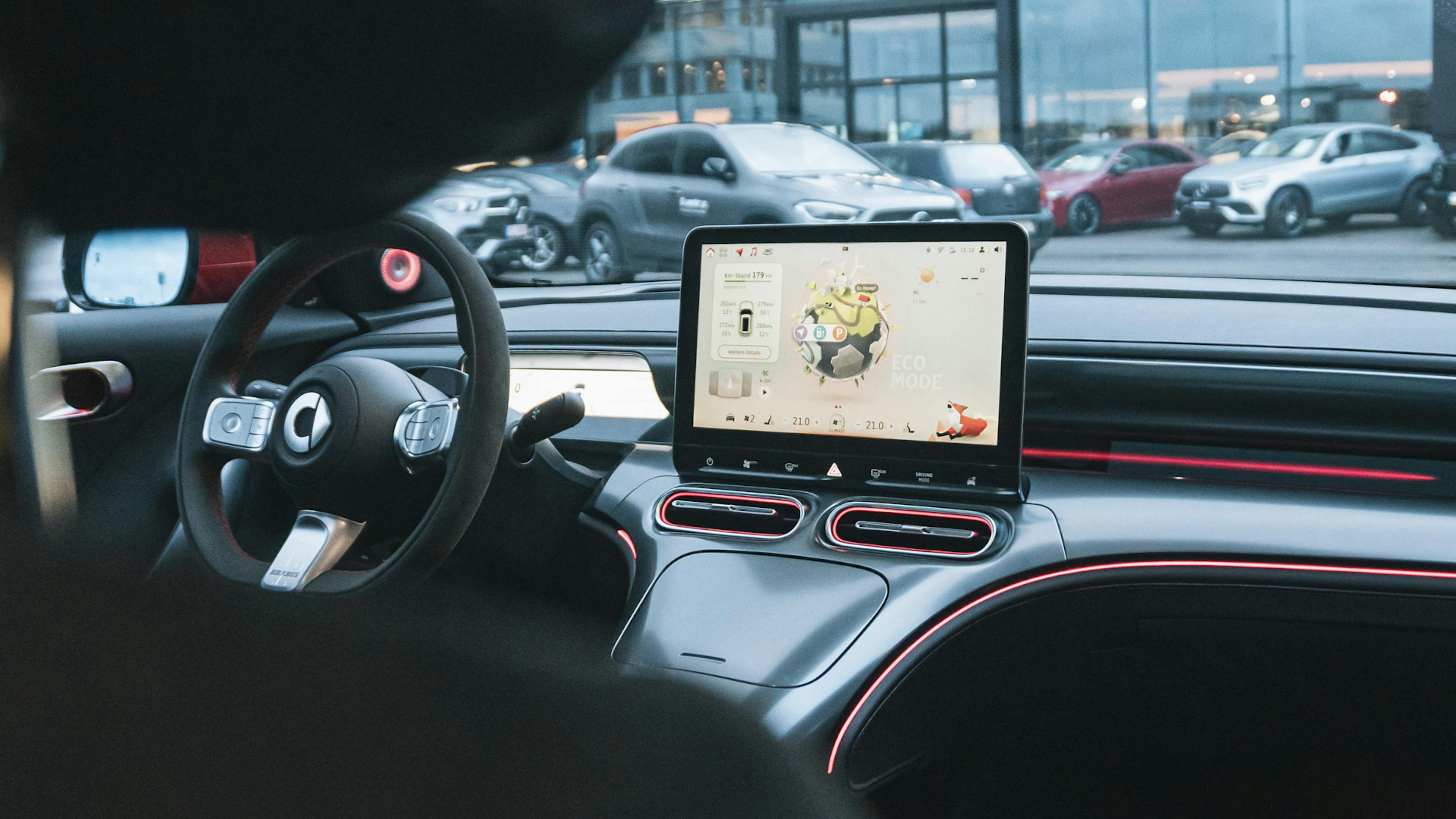 Lenkrad und Touchscreen aus der Sicht der rechten Seite der Rückbank.