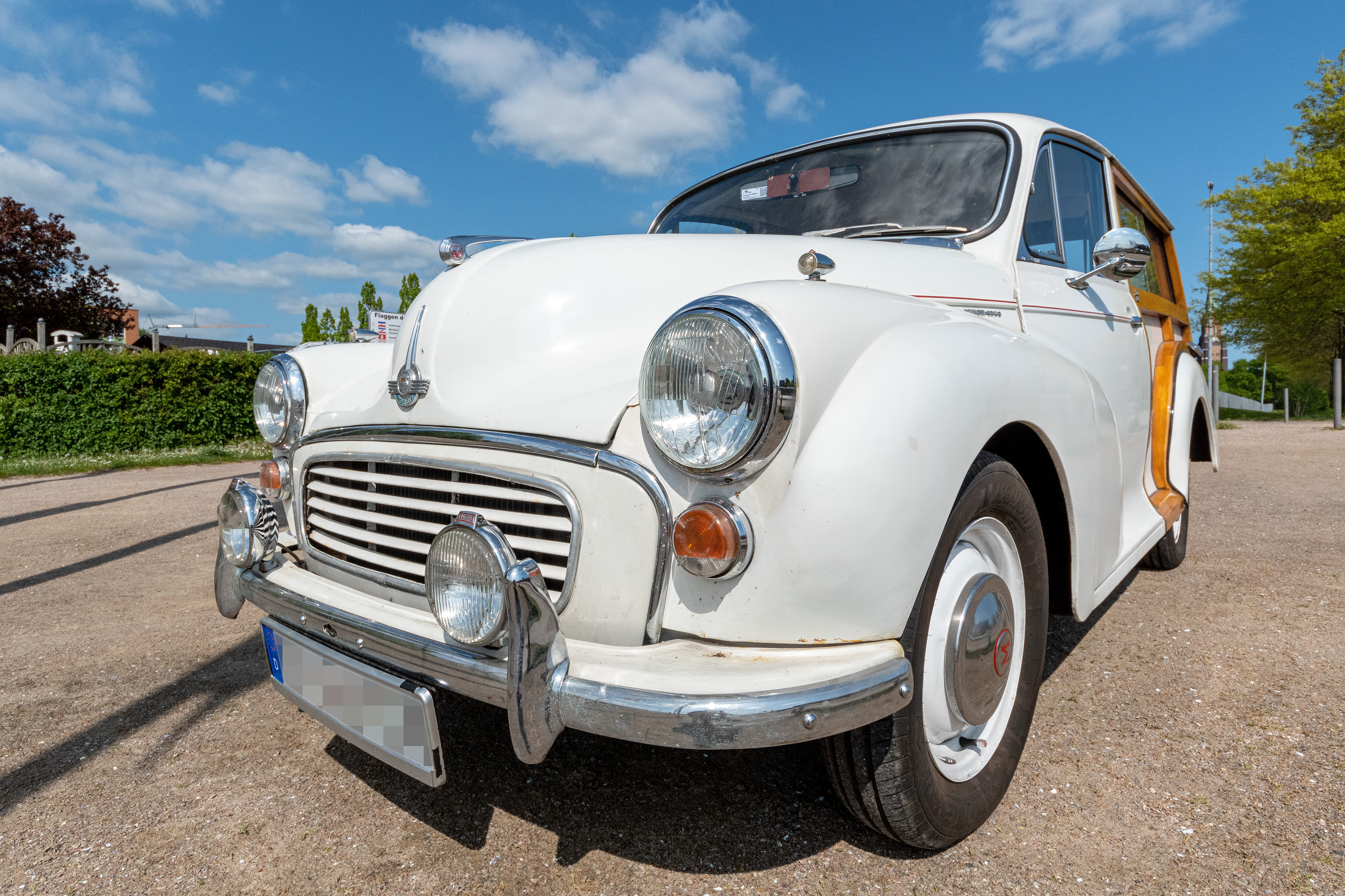 Weißer Morris Minor 1000 Traveler in Frontansicht, geparkter Oldtimer mit Holzrahmen-Heck.