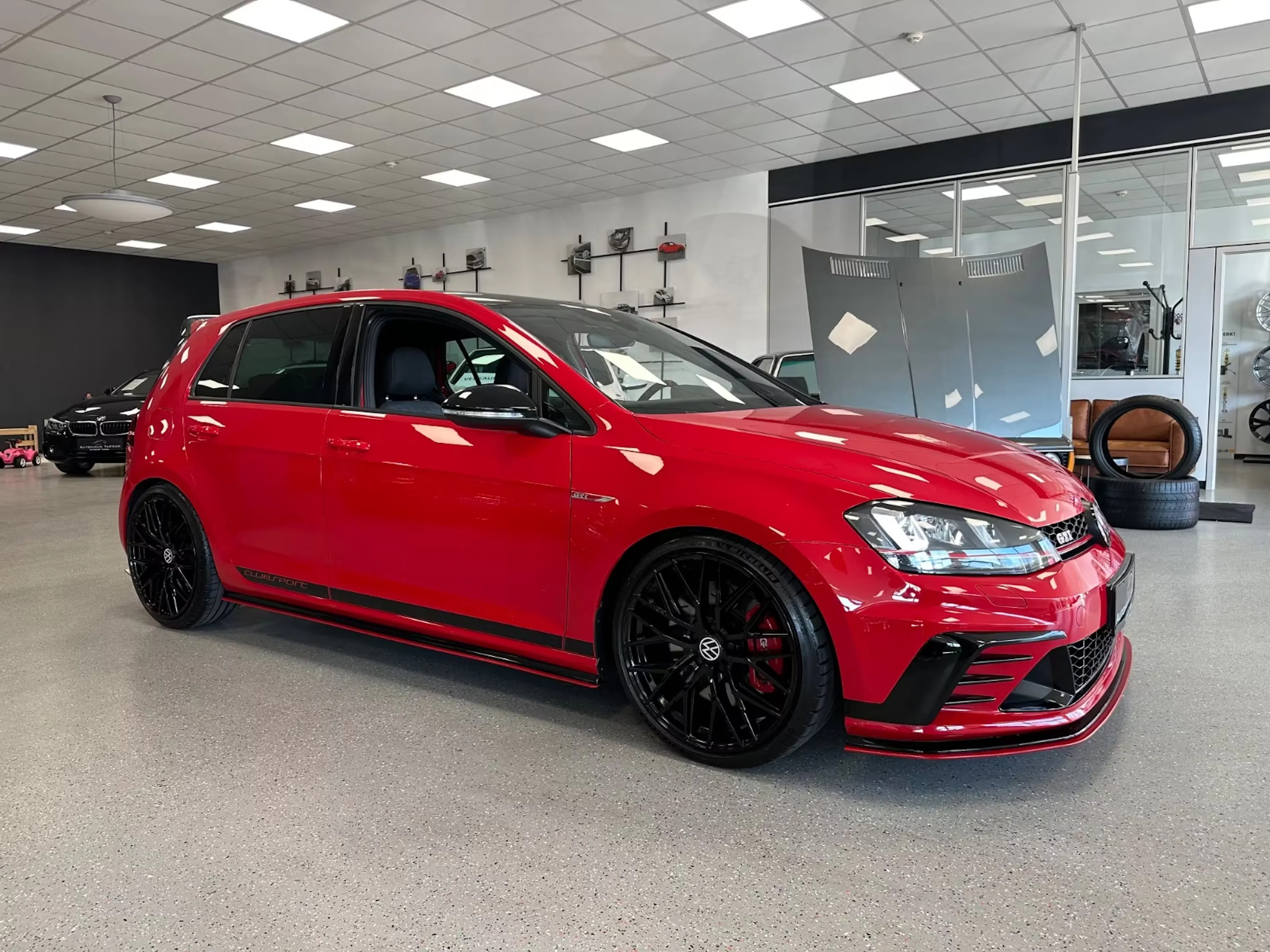 Ein roter Golf VII GTI steht in einer Verkaufshalle beim Händler.