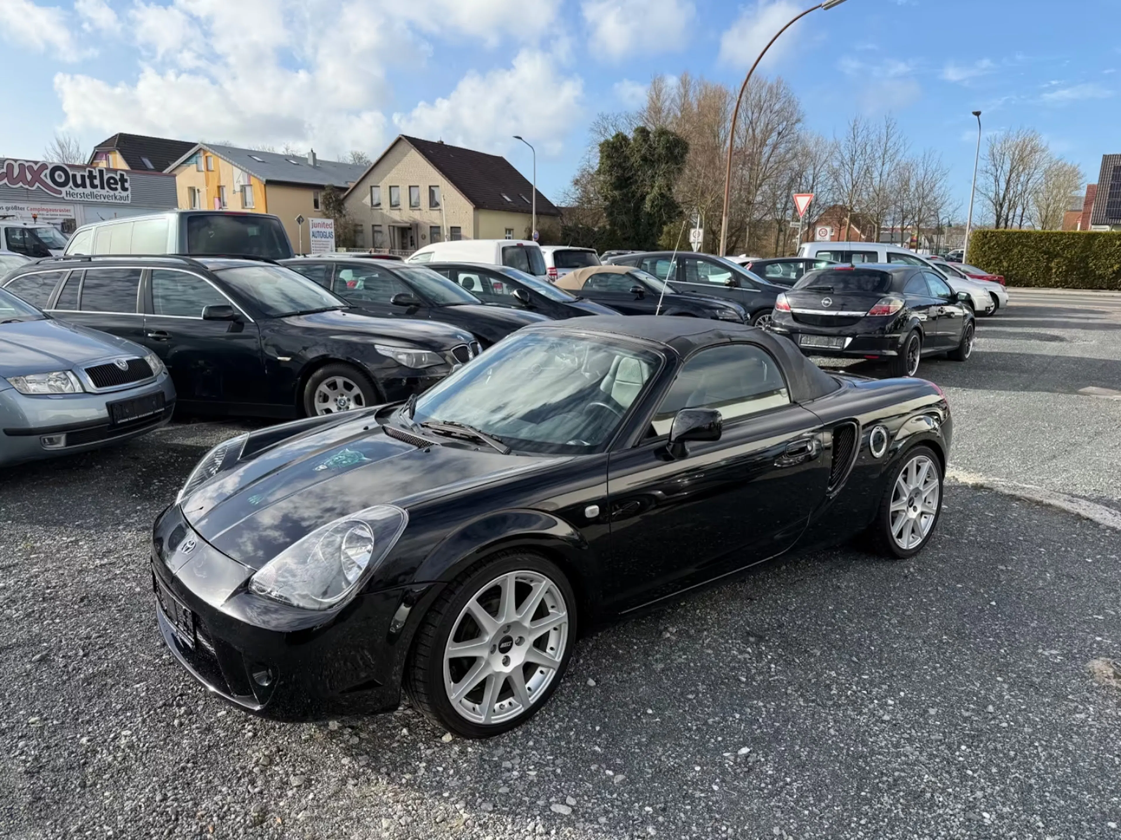 Schwarzer Toyota MR2 steht auf einem Händlerparkplatz.