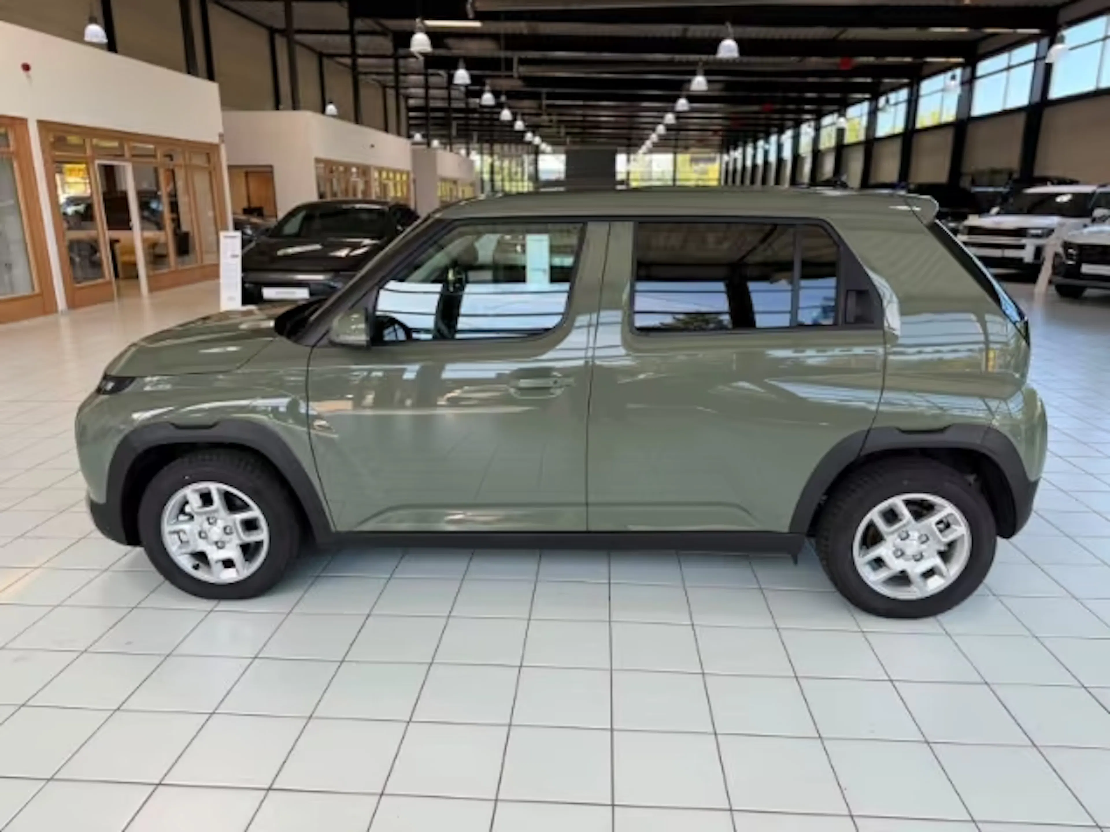 Ein grüner Hyundai Inster steht in einer Verkaufshalle.