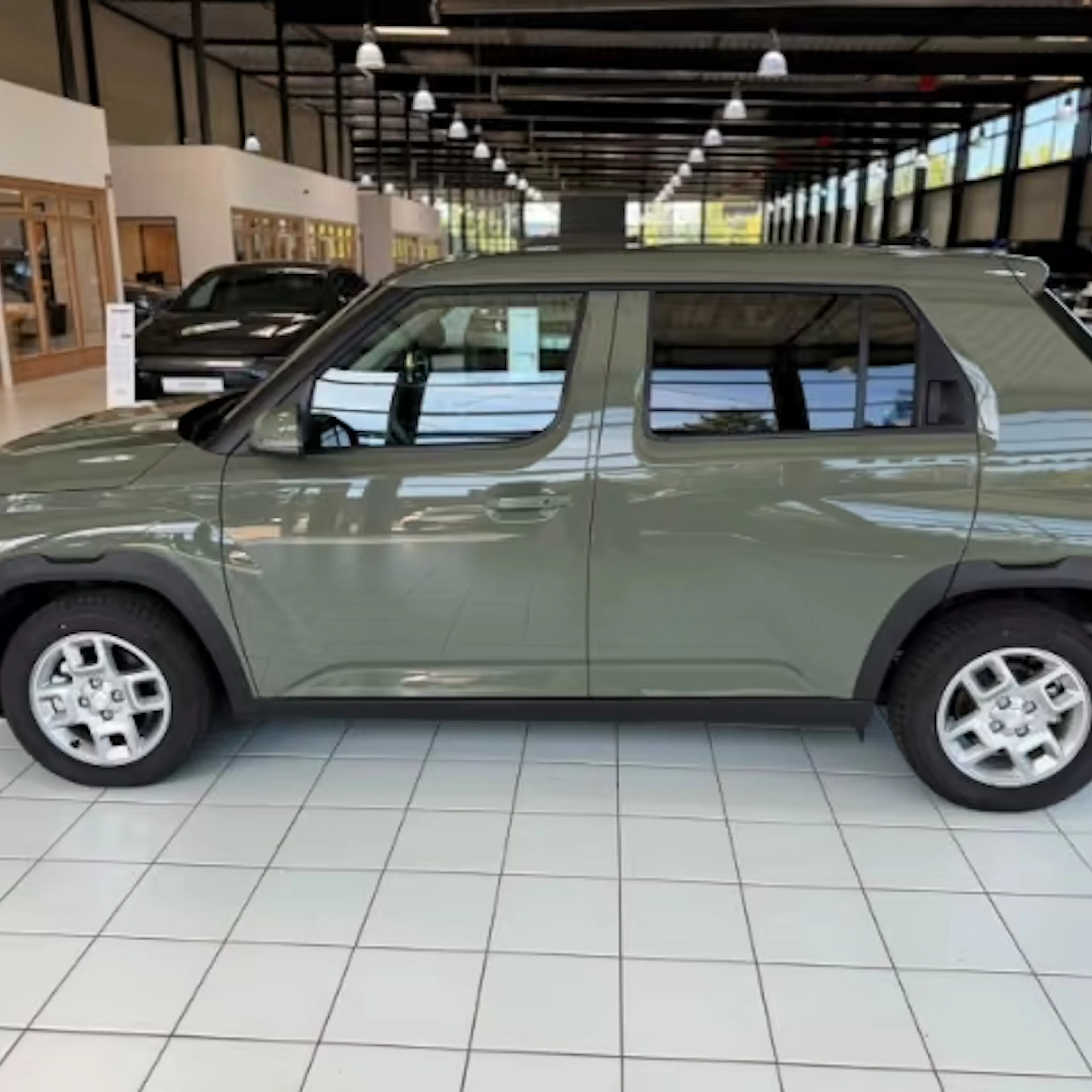 Ein grüner Hyundai Inster steht in einer Verkaufshalle.