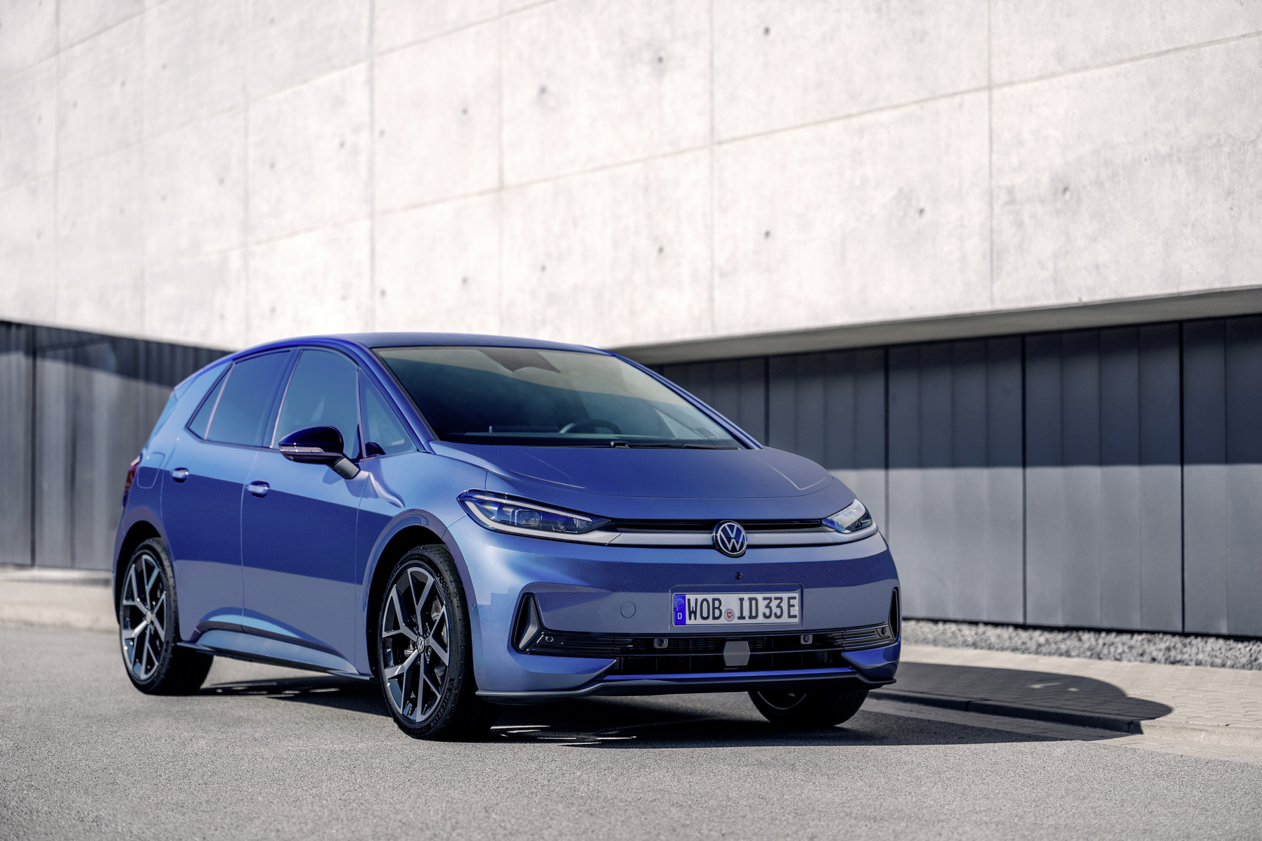 Blauer VW ID.3 Neo steht vor einer grauen Betonwand.