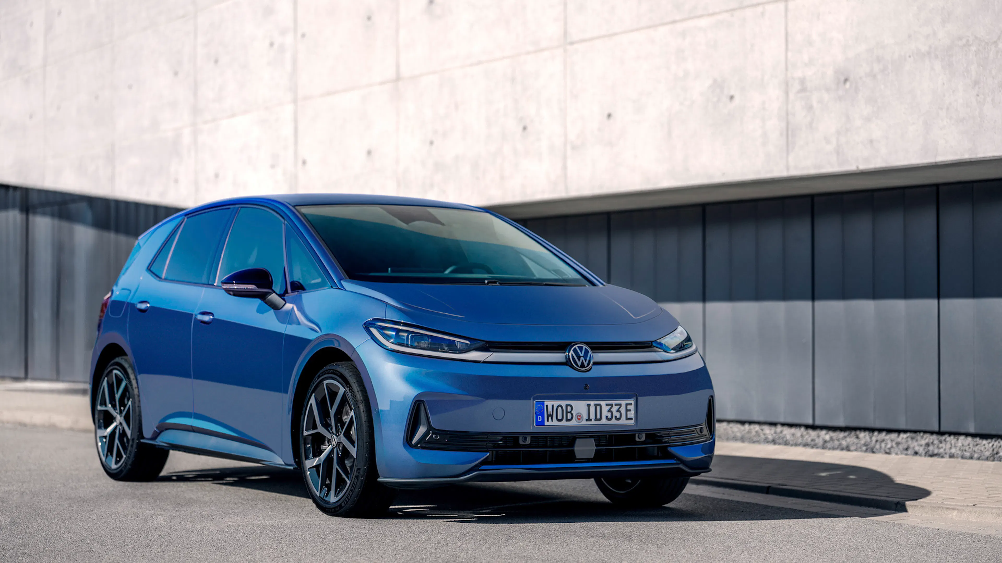 Blauer VW ID.3 Neo steht vor einer grauen Betonwand.