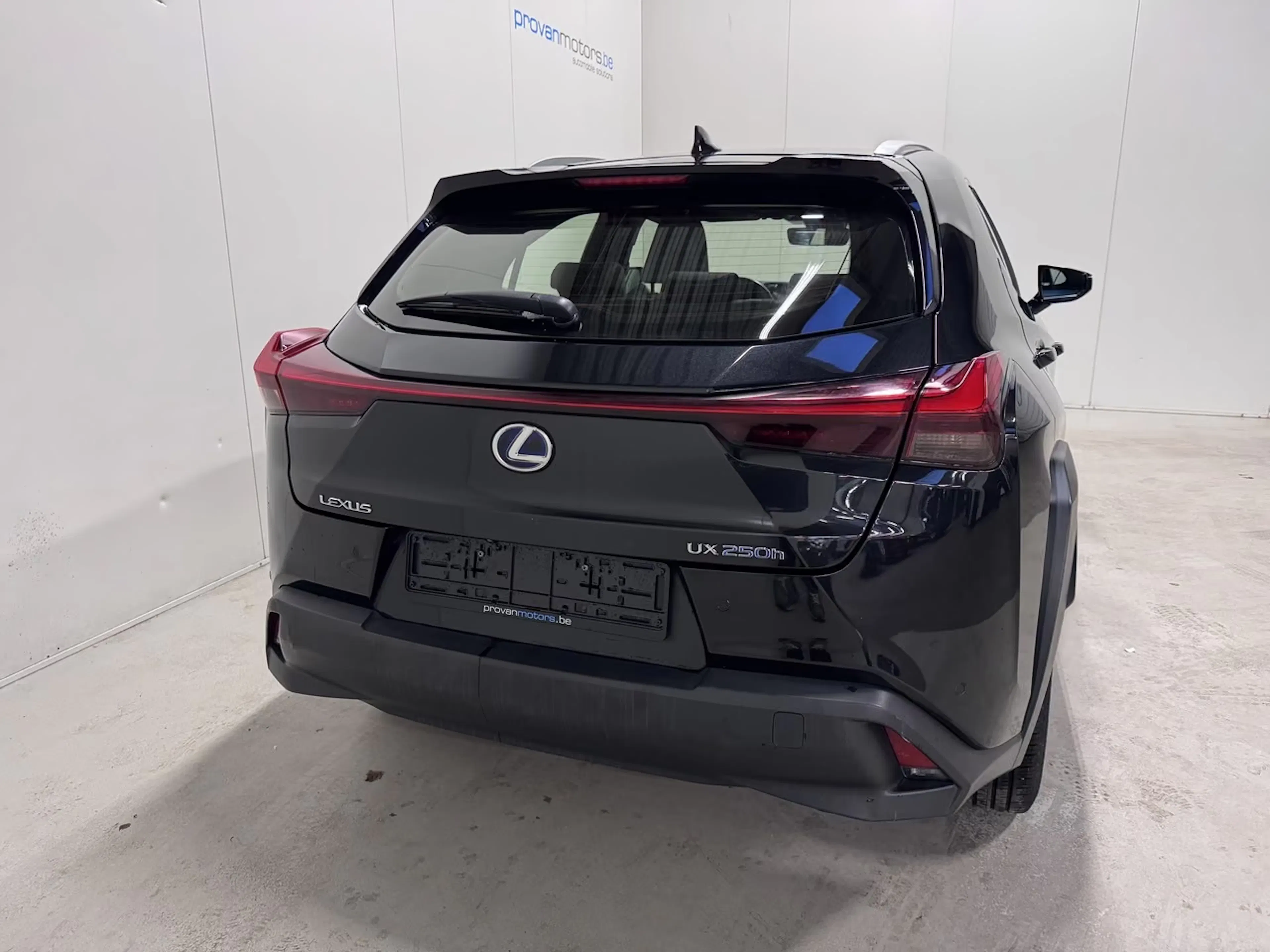 Ein dunkel lackierter Lexus UX steht auf einer Präsentationsfläche.