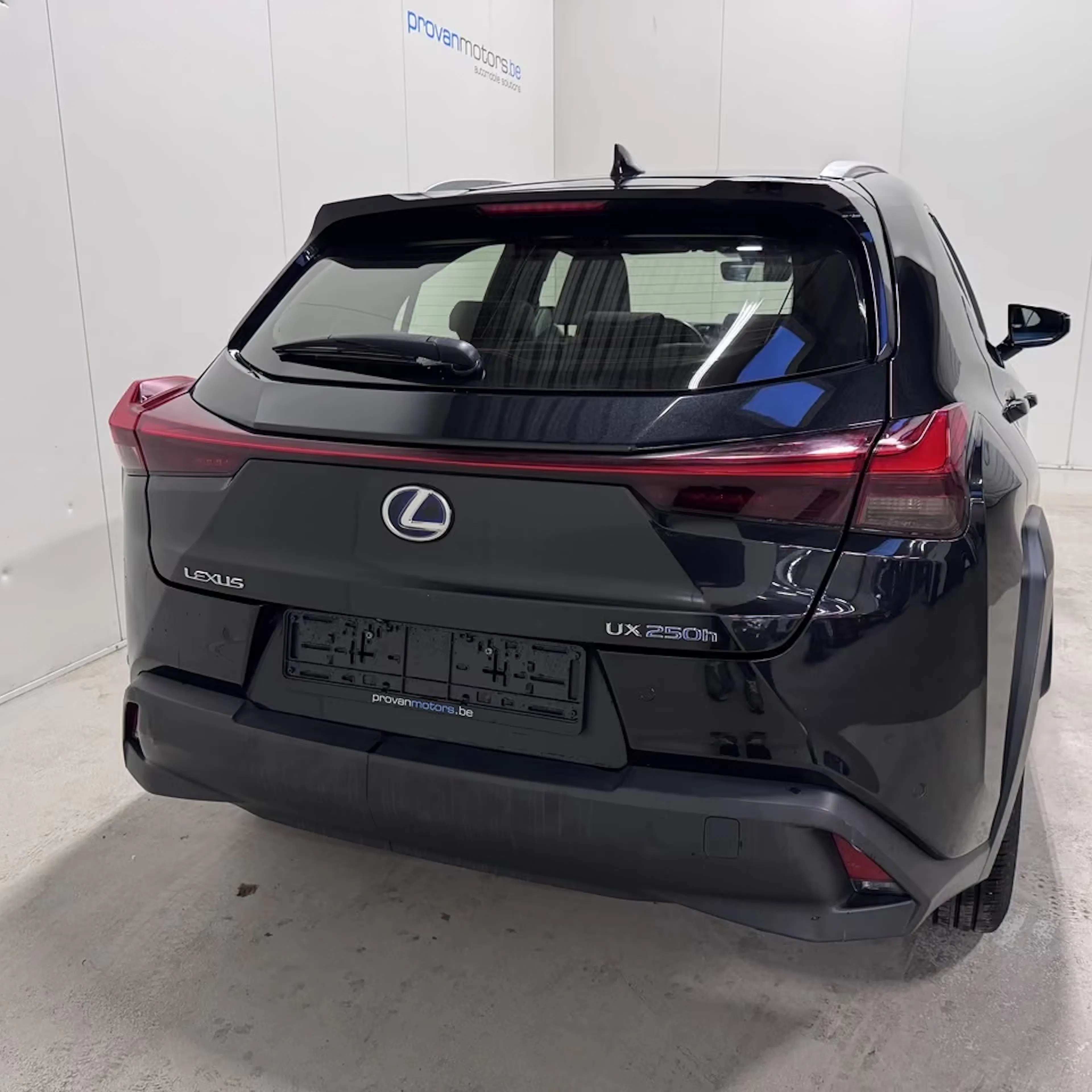 Ein dunkel lackierter Lexus UX steht auf einer Präsentationsfläche.