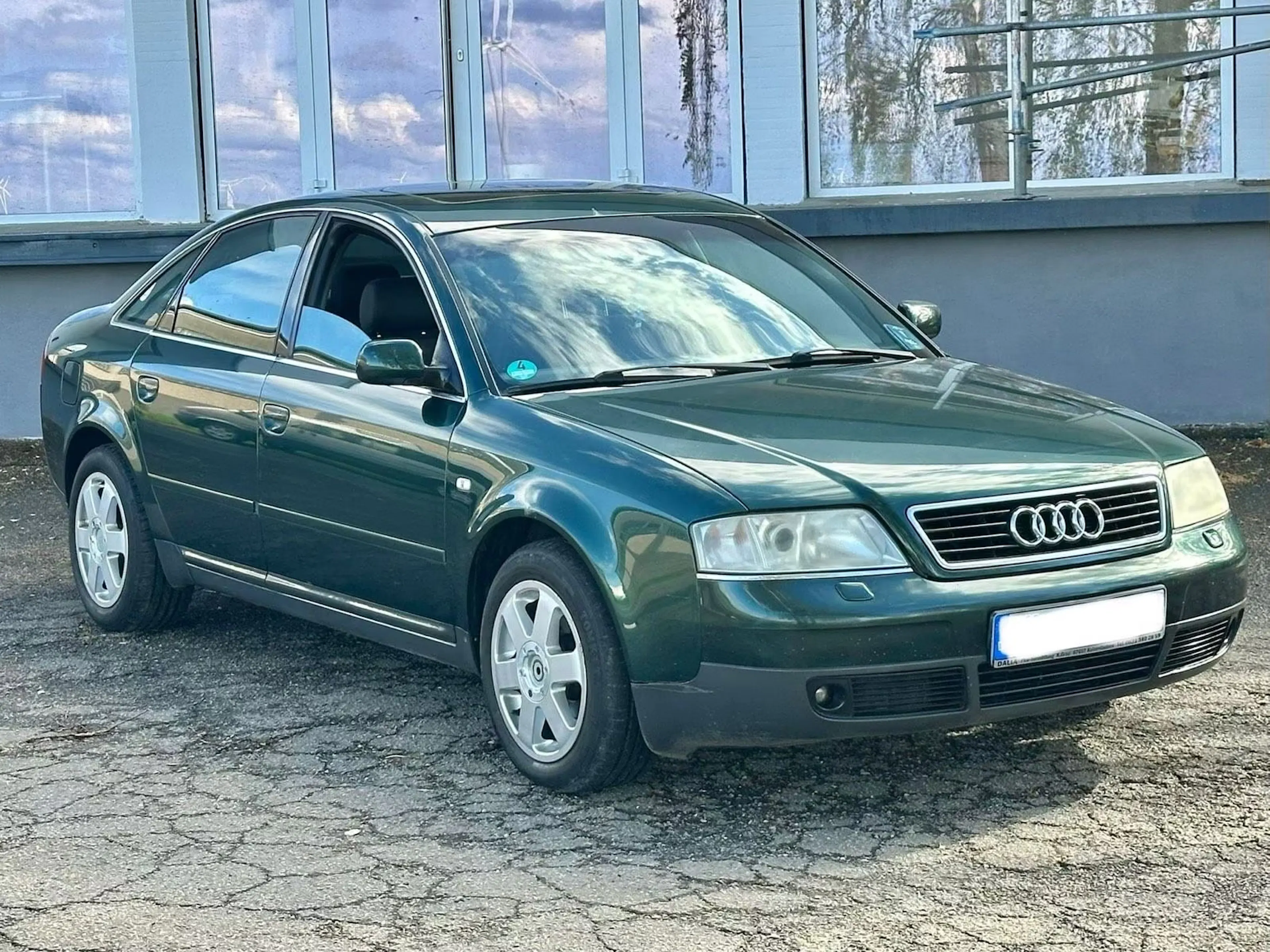 Grüner Audi A6 C5 vor Betonwand