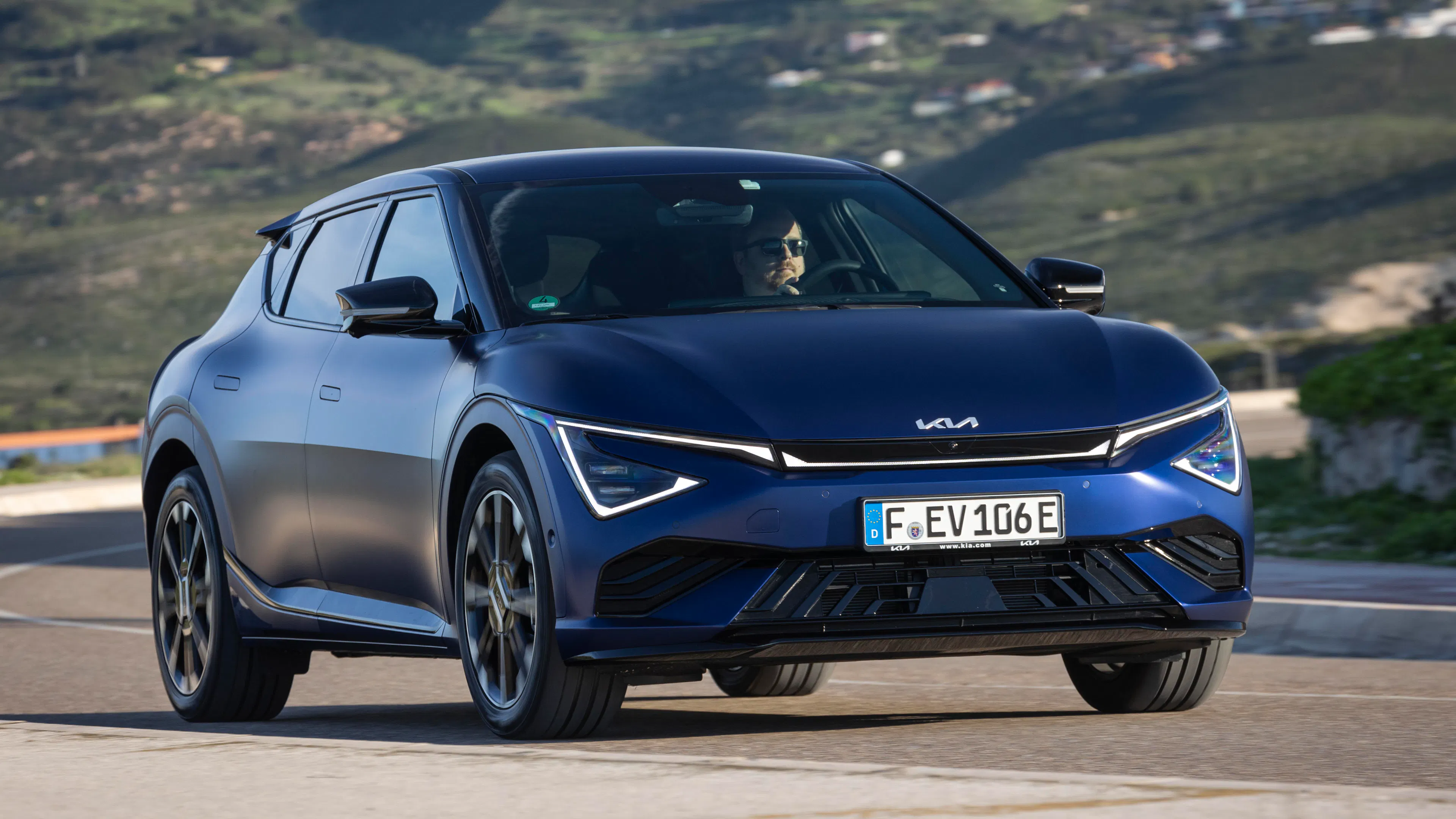 Ein dunkelblauer Kia EV6 steht an einem See.