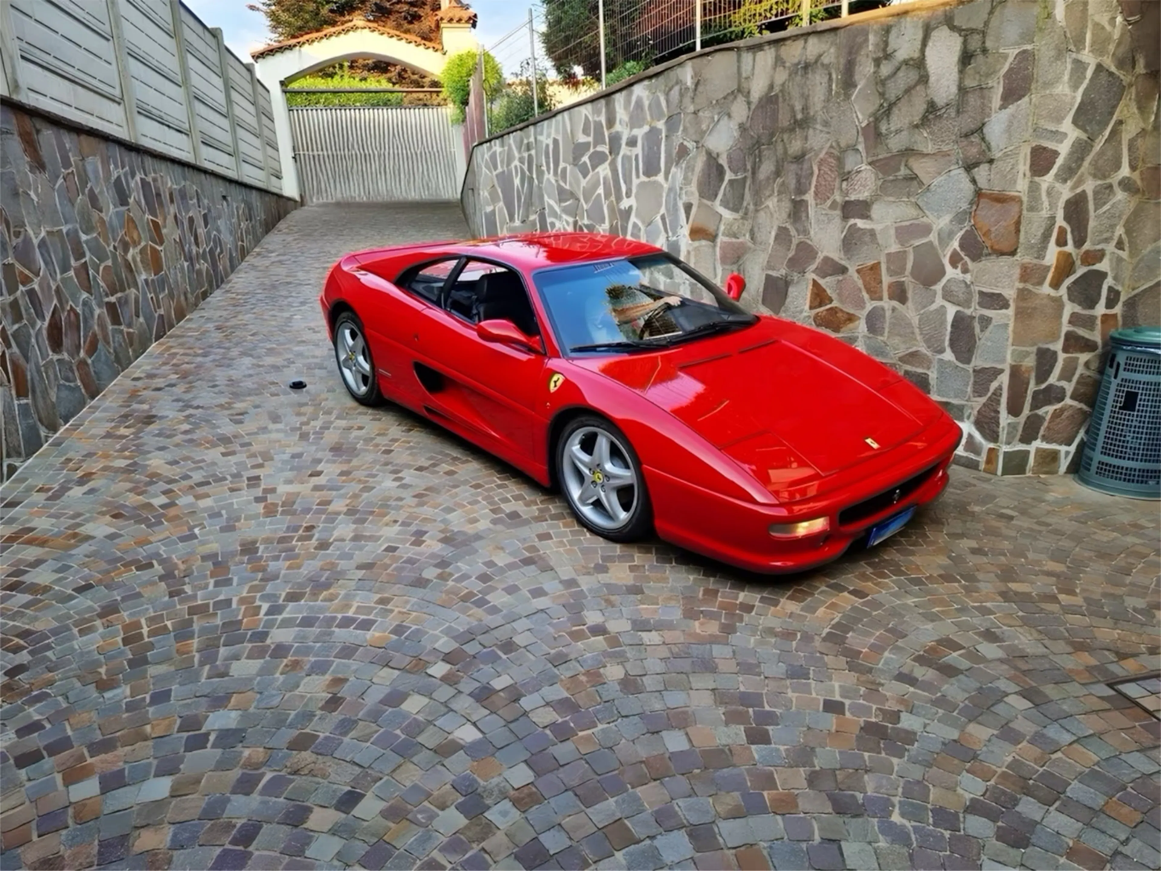 Roter Ferrari F355 vor gemauerter Wand