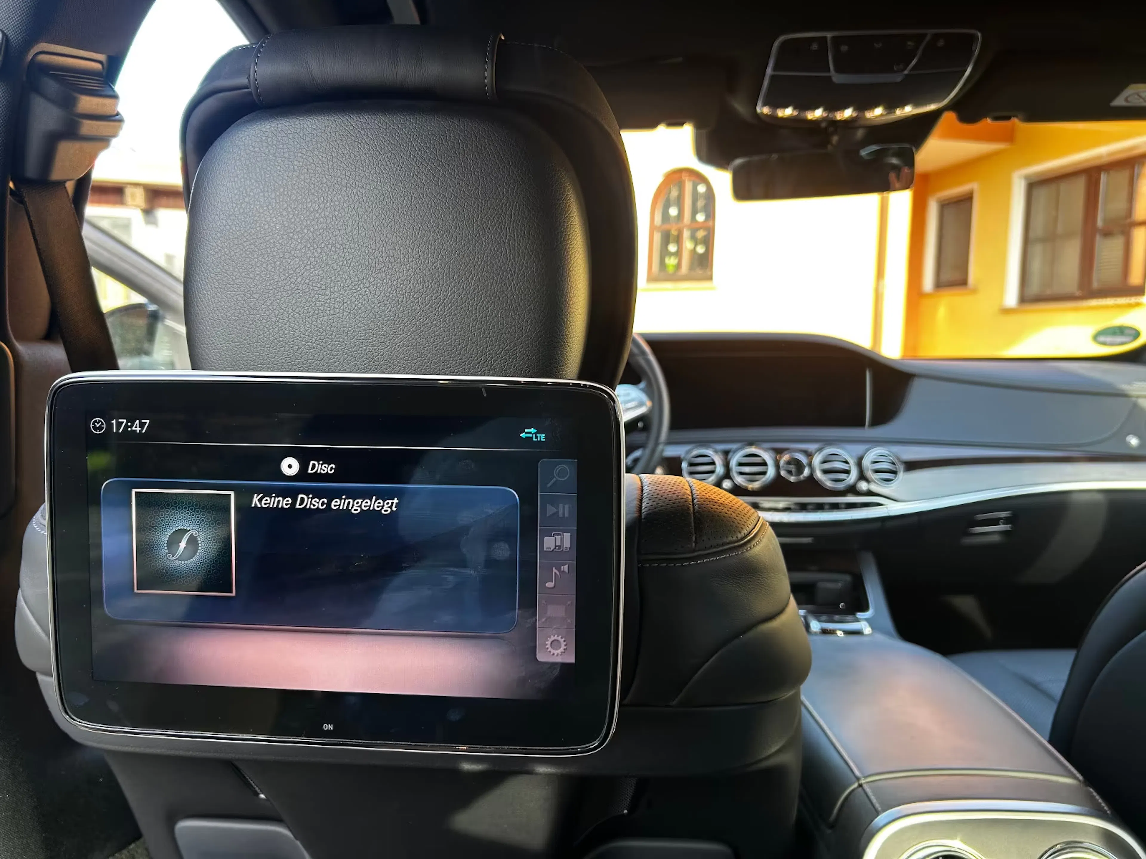 Blick in den Innenraum des Mercedes-Benz. Es ist ein Display zu sehen, das an der Rückseite des Fahrersitzes angebracht ist.