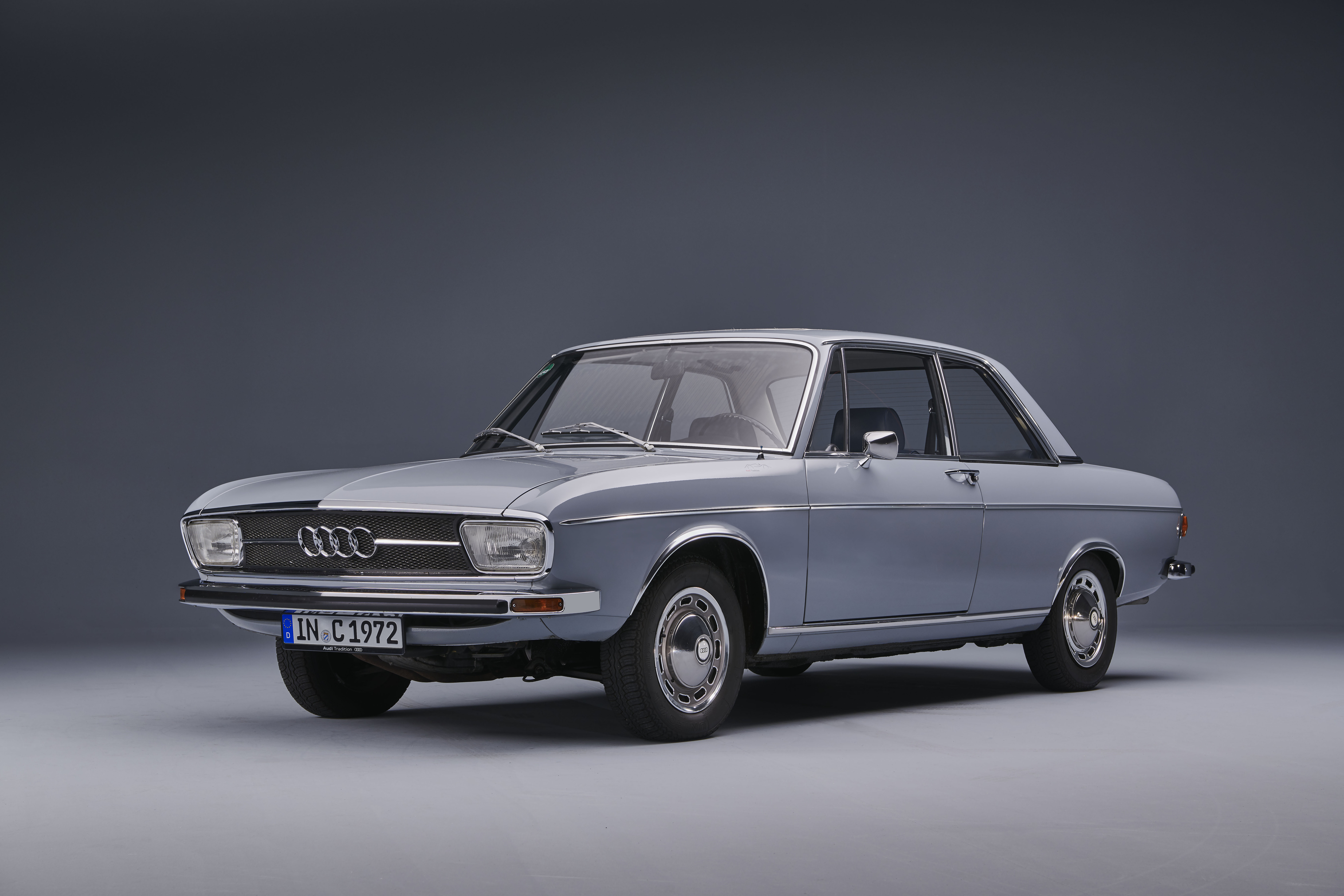 Audi 100 C1 als Limousine der ersten Generation, schräg von vorn fotografiert im Studio.