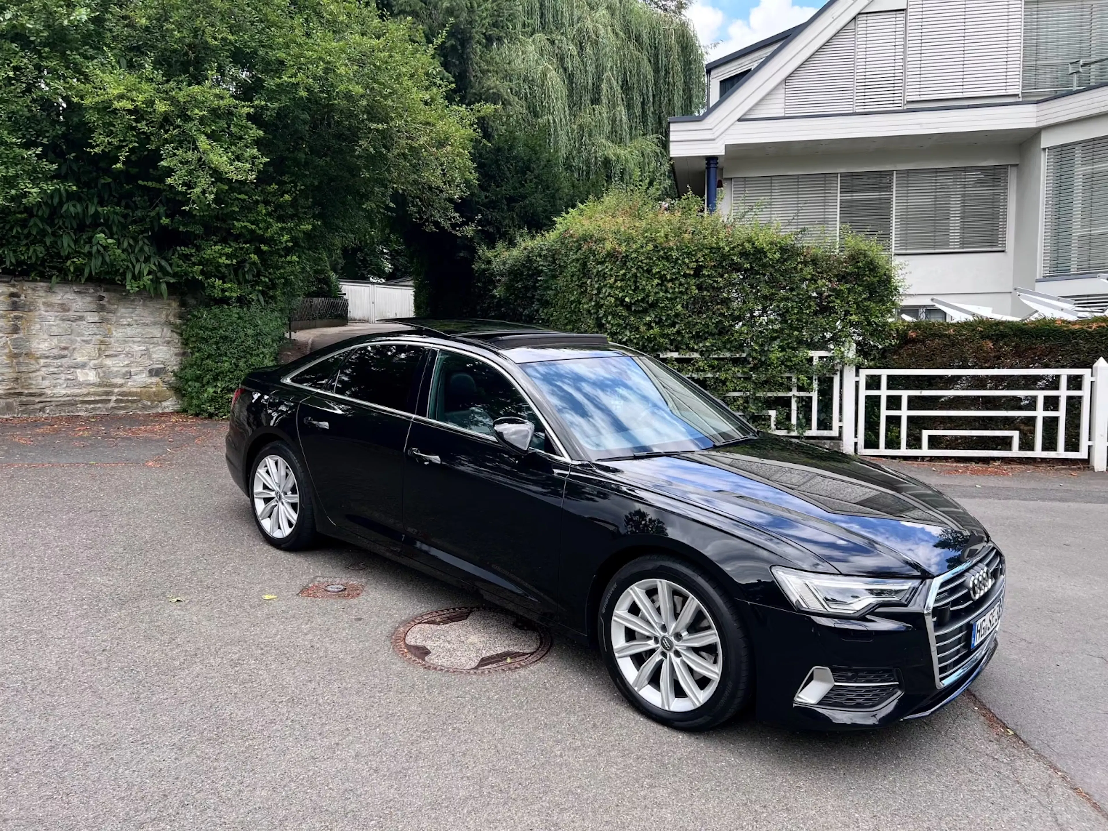 Schwarzer Audi A6 C8 in Hauseinfahrt