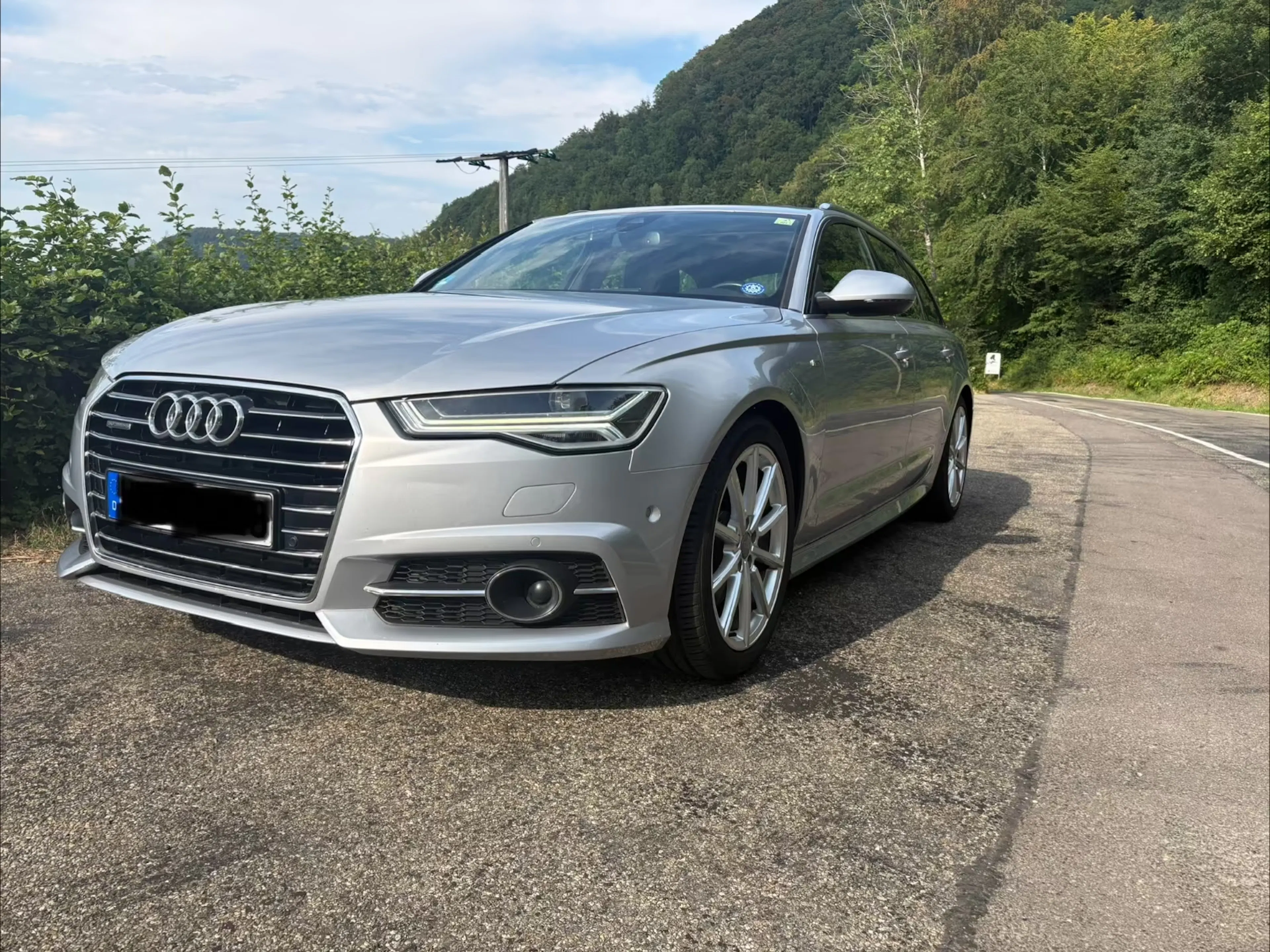 Silberner Audi A6 C7 neben Landstraße