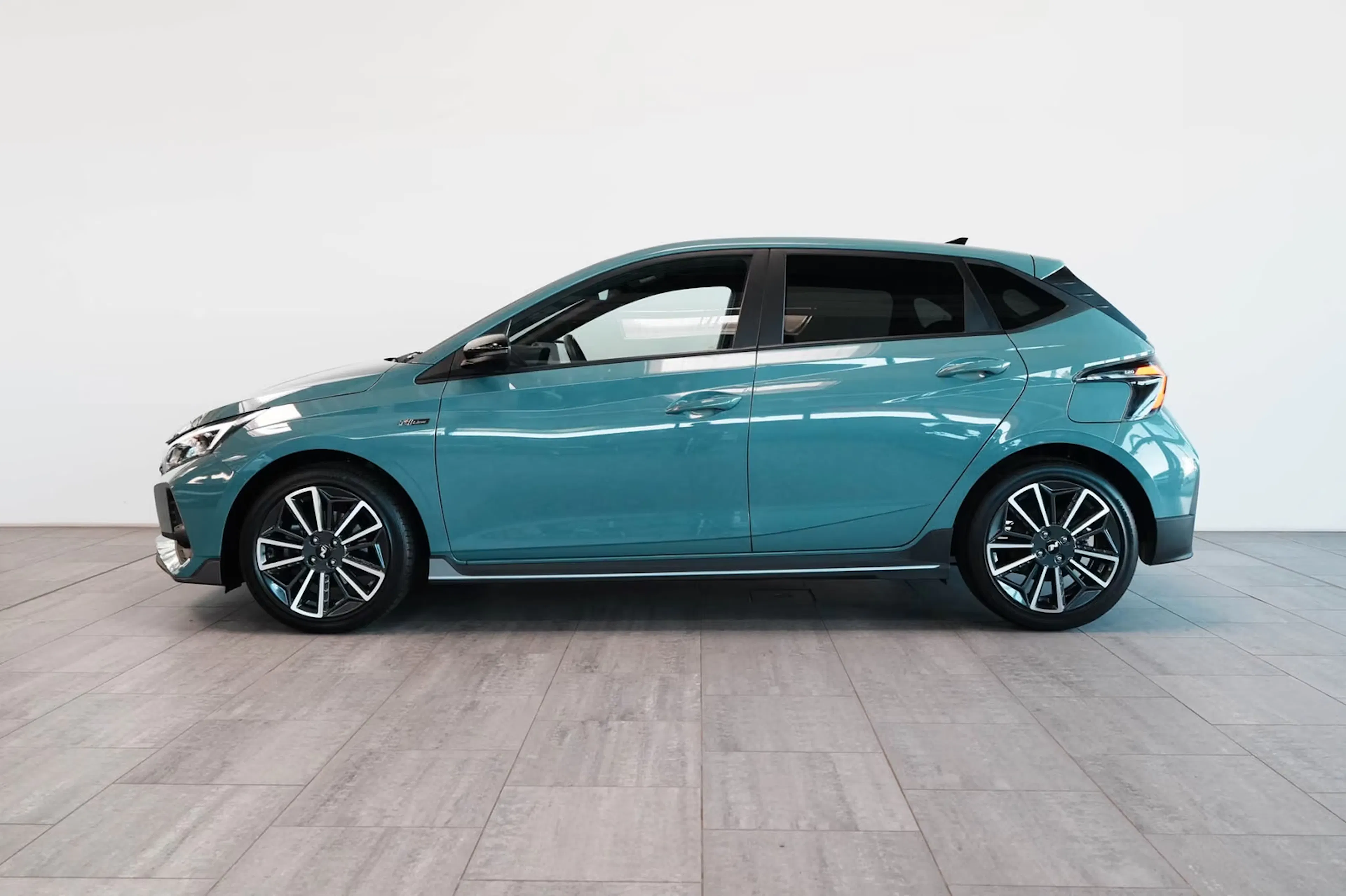 Ein türkisfarbener Hyundai i20 steht auf einer Präsentationsfläche.