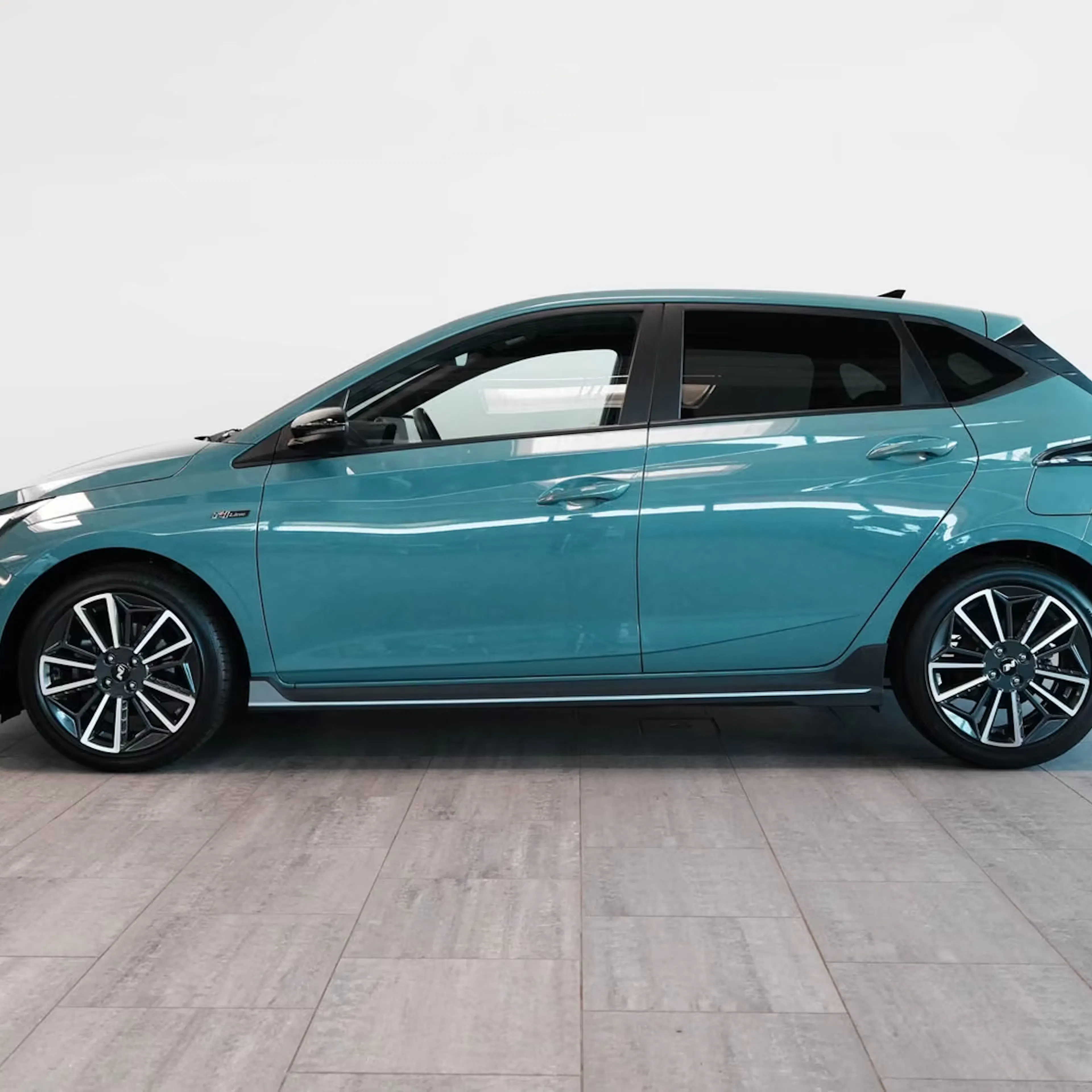 Ein türkisfarbener Hyundai i20 steht auf einer Präsentationsfläche.