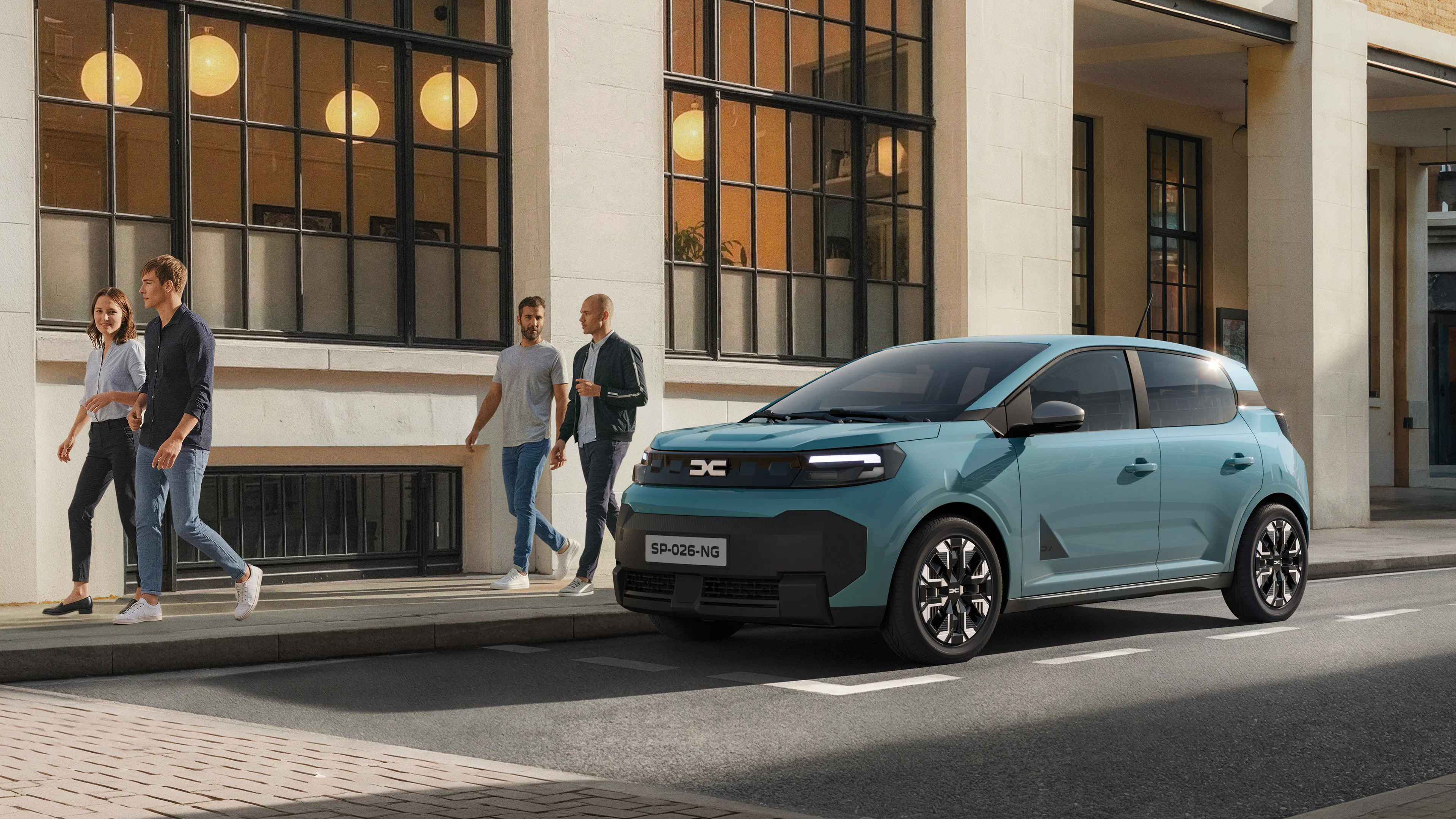 Seitenansicht des Dacia Spring 2 in Hellblau vor einer Häuserfront.