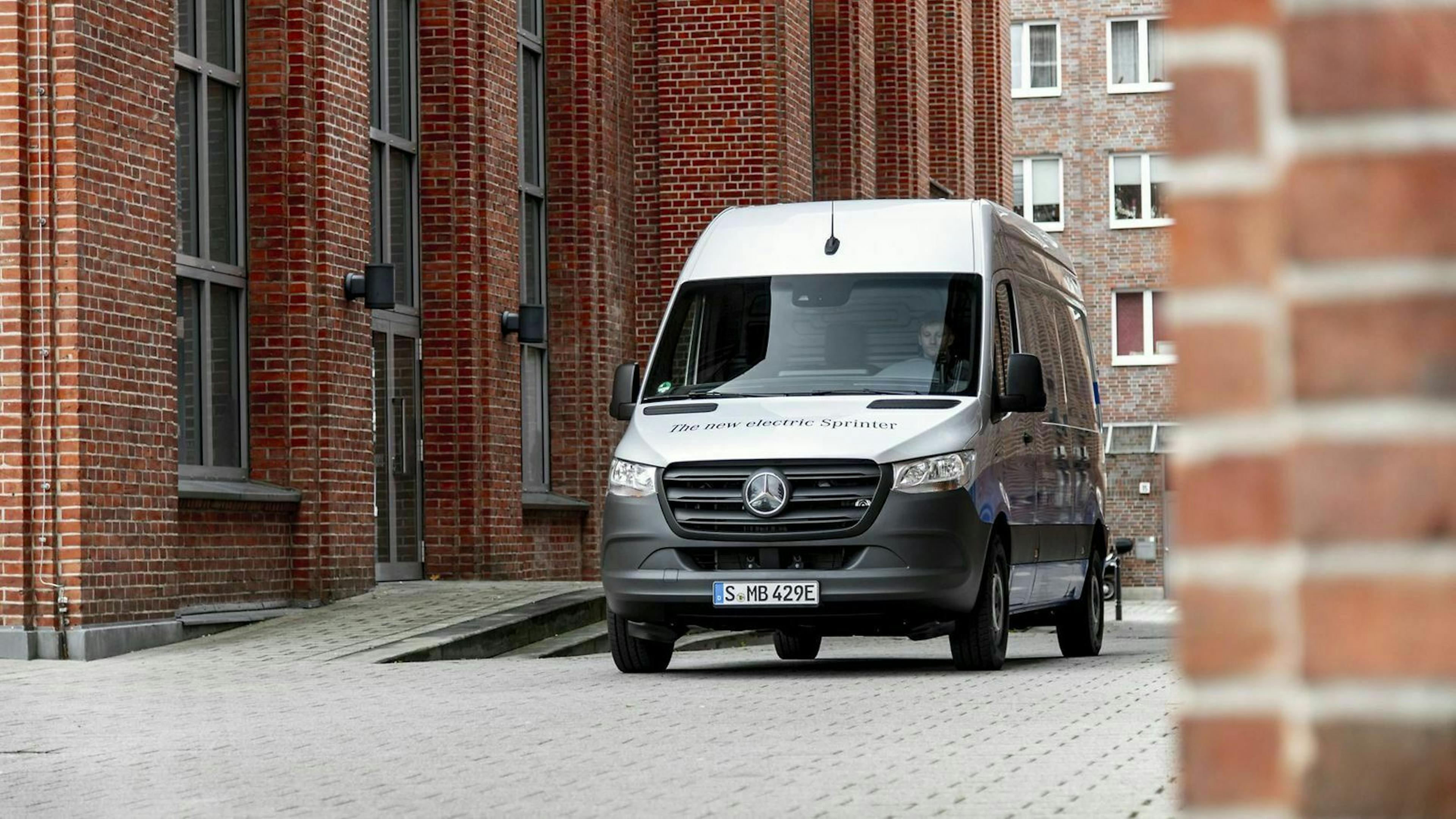 Mercedes eSprinter in der Frontansicht, zwischen zwei Backsteingebäuden stehend