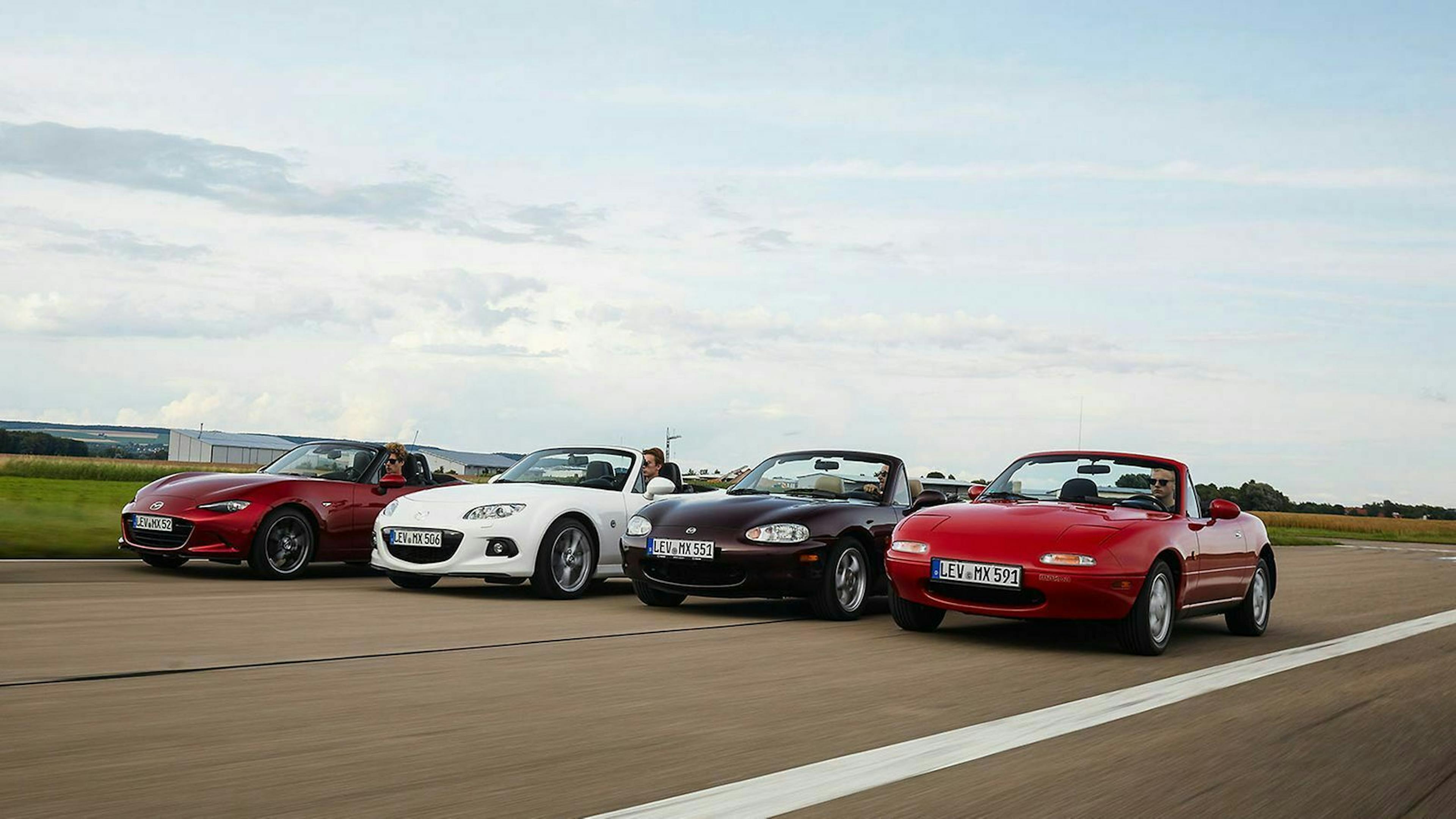 Vier Generationen des Mazda MX-5 fahren nebeneinander