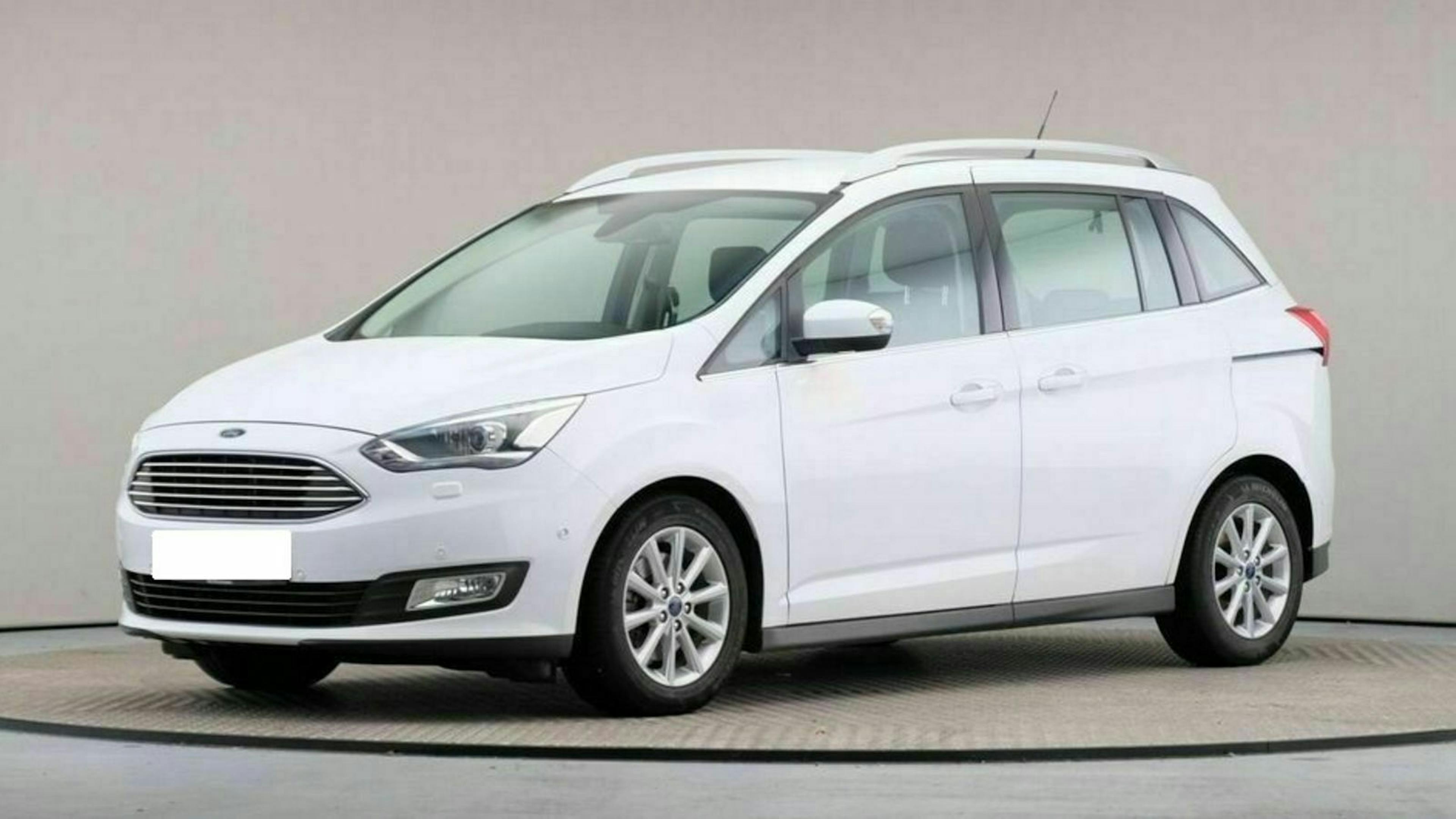 Weißer Minivan in Studioaufnahme, seitlich von vorne fotografiert, auf einem drehbaren Podest.