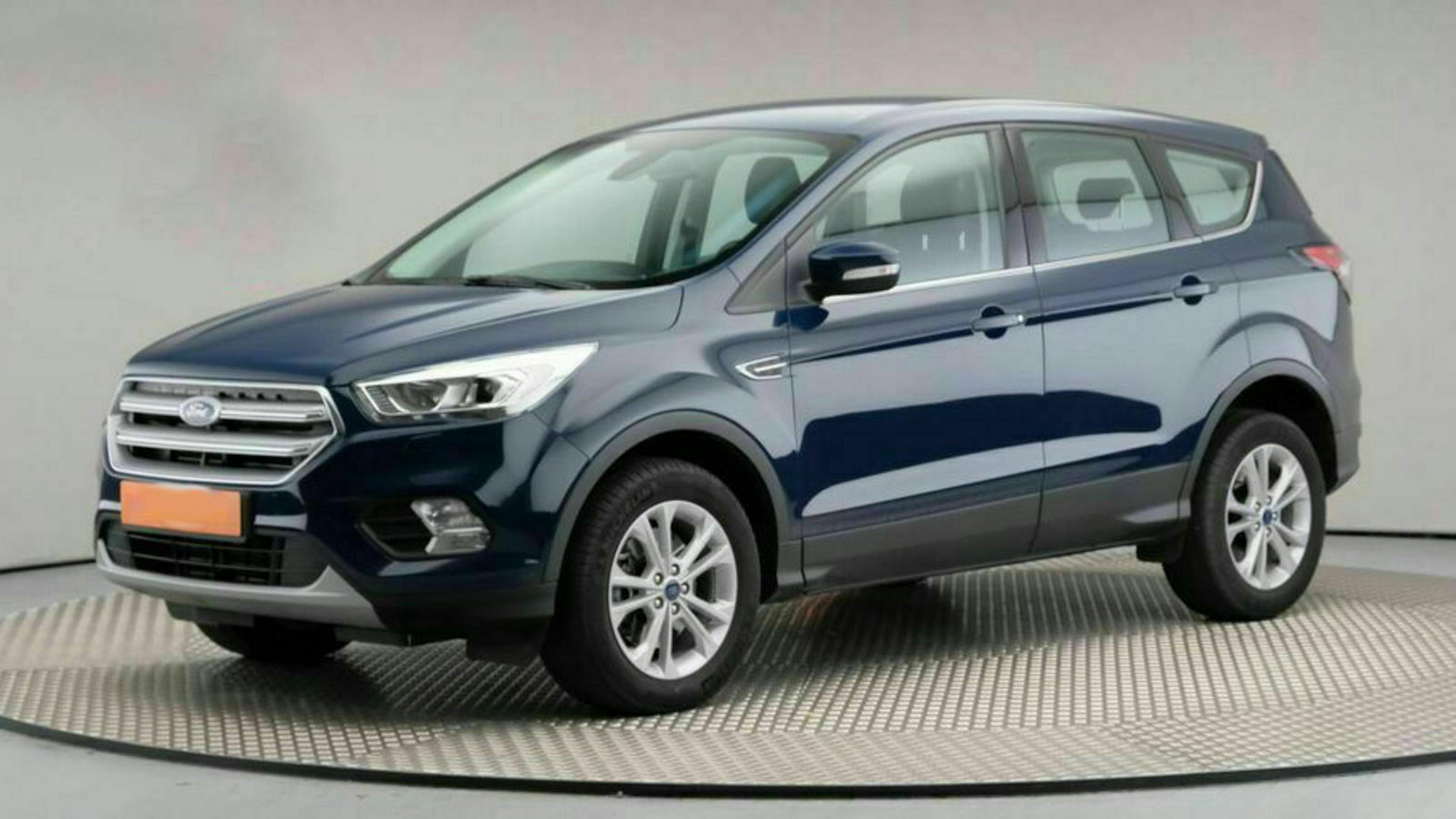 Blauer SUV steht in einem Showroom auf einem drehbaren Podest, seitliche Ansicht.