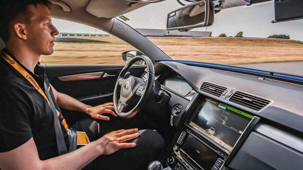 Ein Entwicklungsingenieur fährt in einem VW Passat B7 bei aktivierter Cruising Chauffeur Funktion