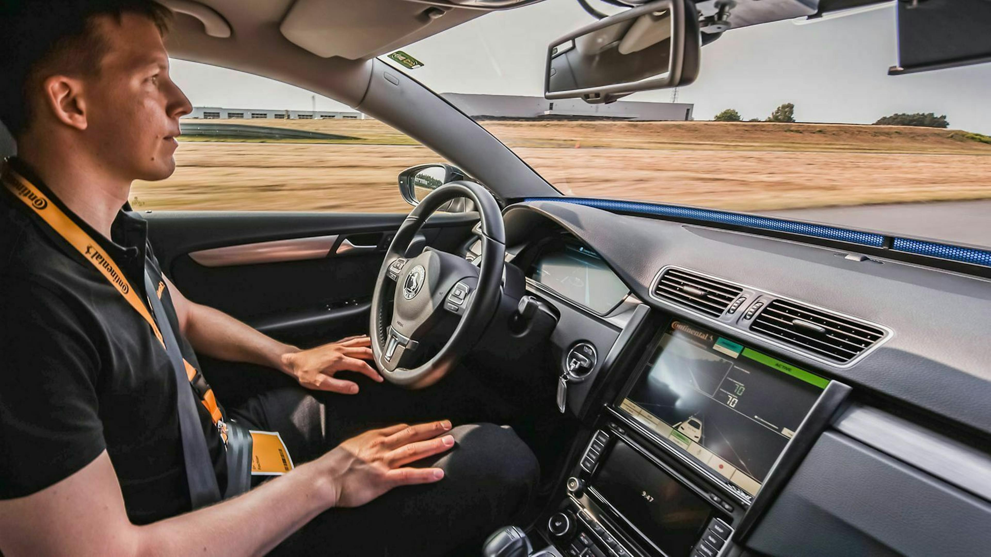 Ein Entwicklungsingenieur  fährt in einem VW Passat B7 bei aktivierter Cruising Chauffeur Funktion