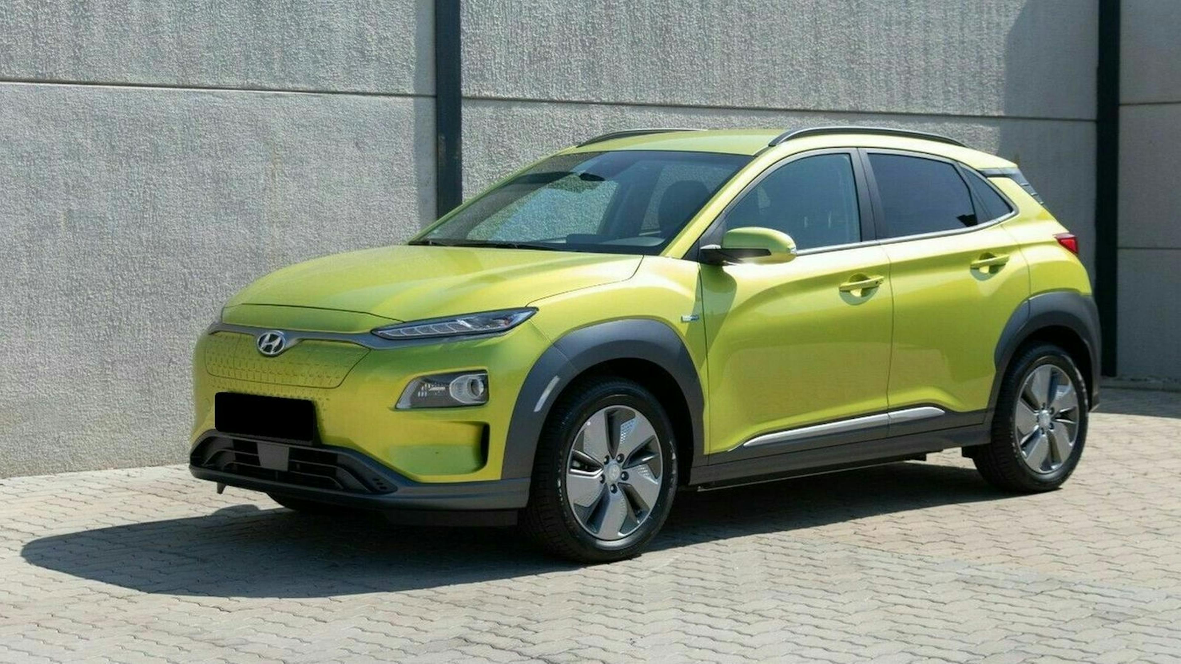 Leuchtend grünes SUV in urbaner Umgebung, schräg von vorne fotografiert. Moderner, kompakter Look mit schwarzen Verzierungen und glatten Linien.