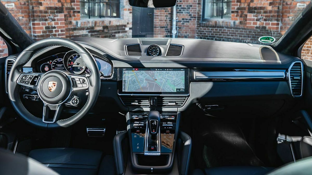 Cockpit-Ansicht des Porsche Cayenne. Straßenkarte auf dem Infotainment-Bildschirm abgebildet