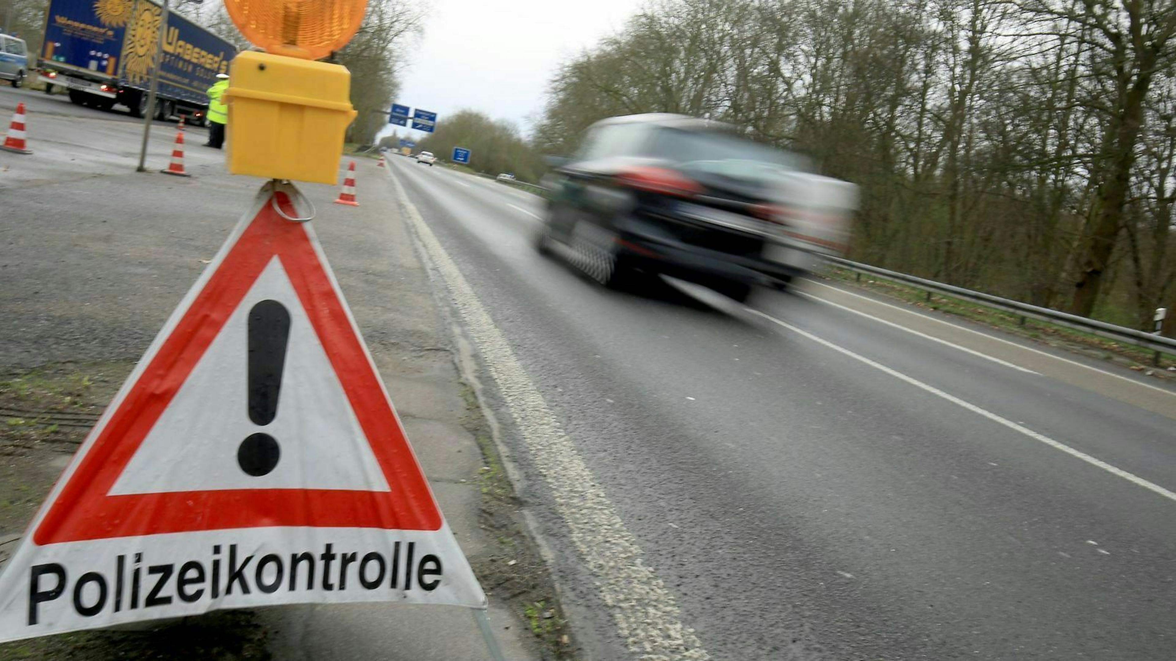 Auto fährt an einer Polizeikontrolle vorbei