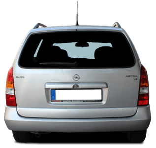 Rückansicht eines silbernen Kombis mit einem deutschen Kennzeichen, schwarzer Fensterabdeckung und Dachreling.