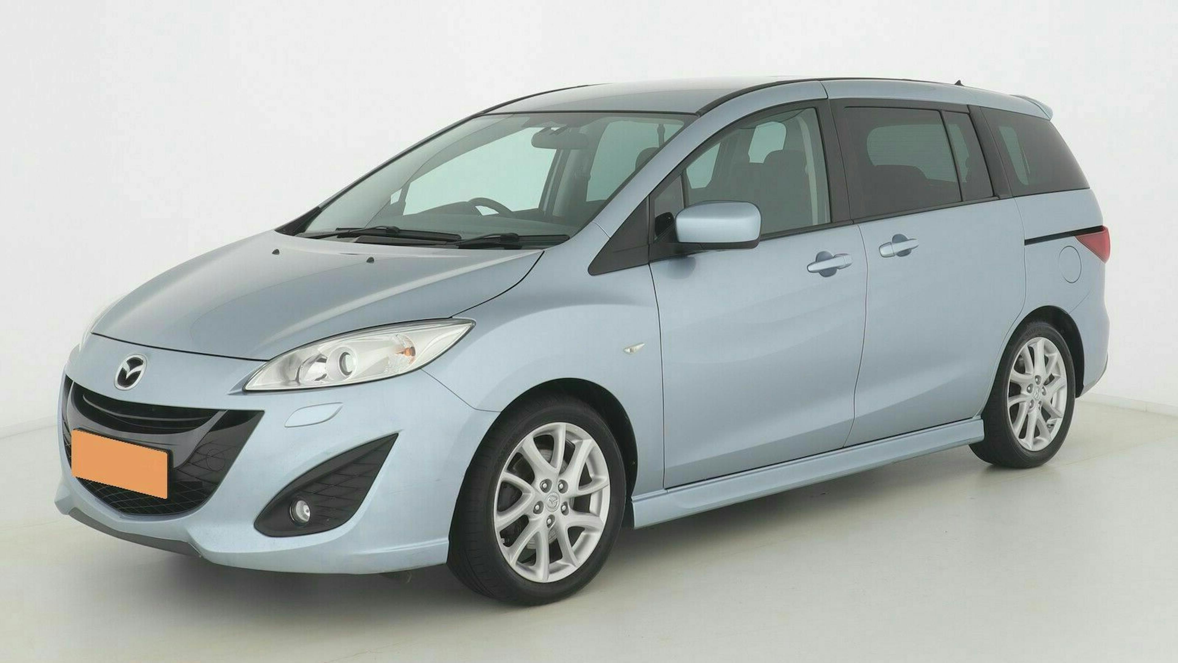 Silberner Mazda Minivan in Seitenansicht auf weißem Hintergrund, mit geschlossenen Fenstern und Leichtmetallfelgen.