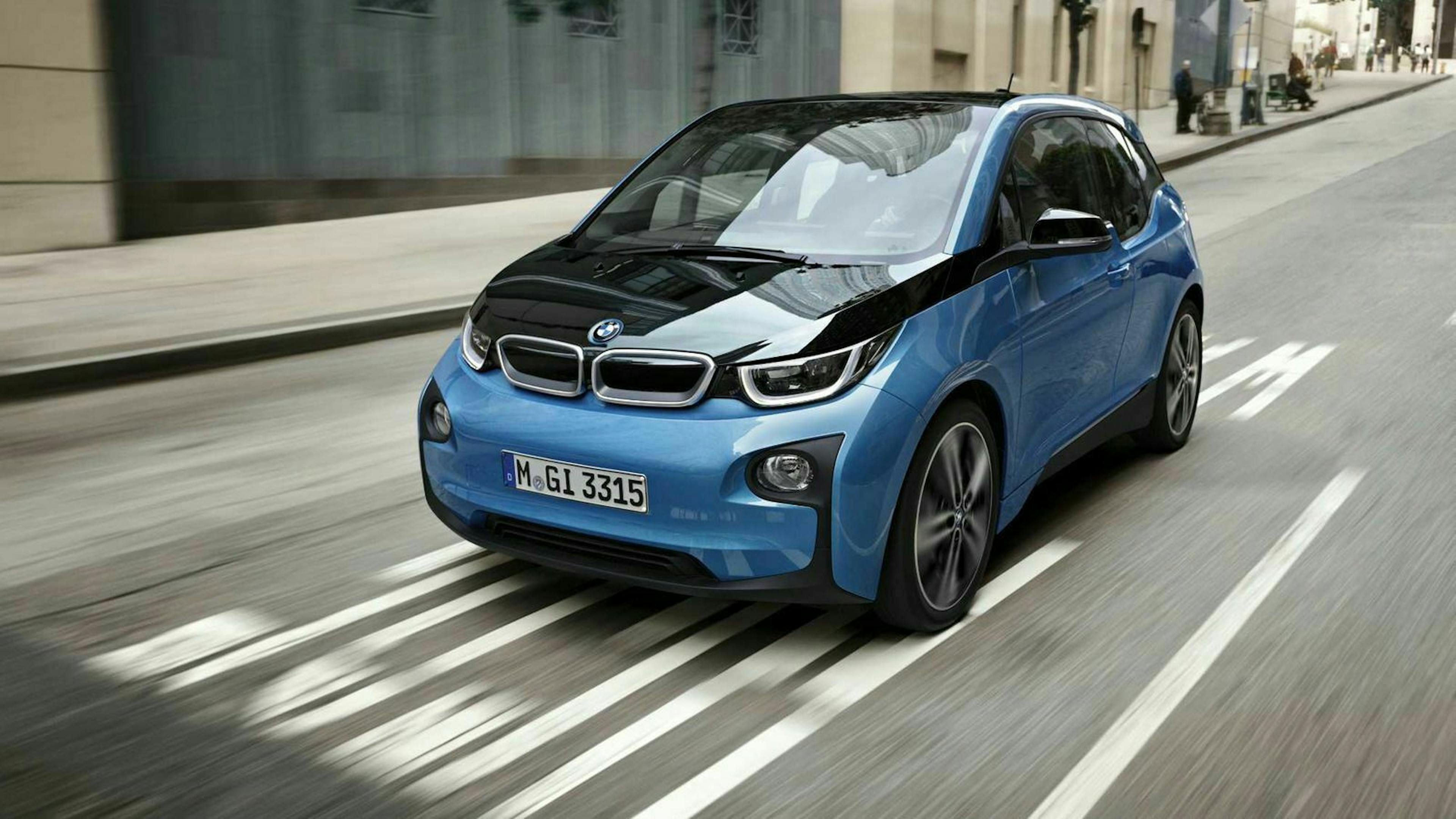 Ein schwarz-blauer BMW i3 fährt eine Straße entlang.