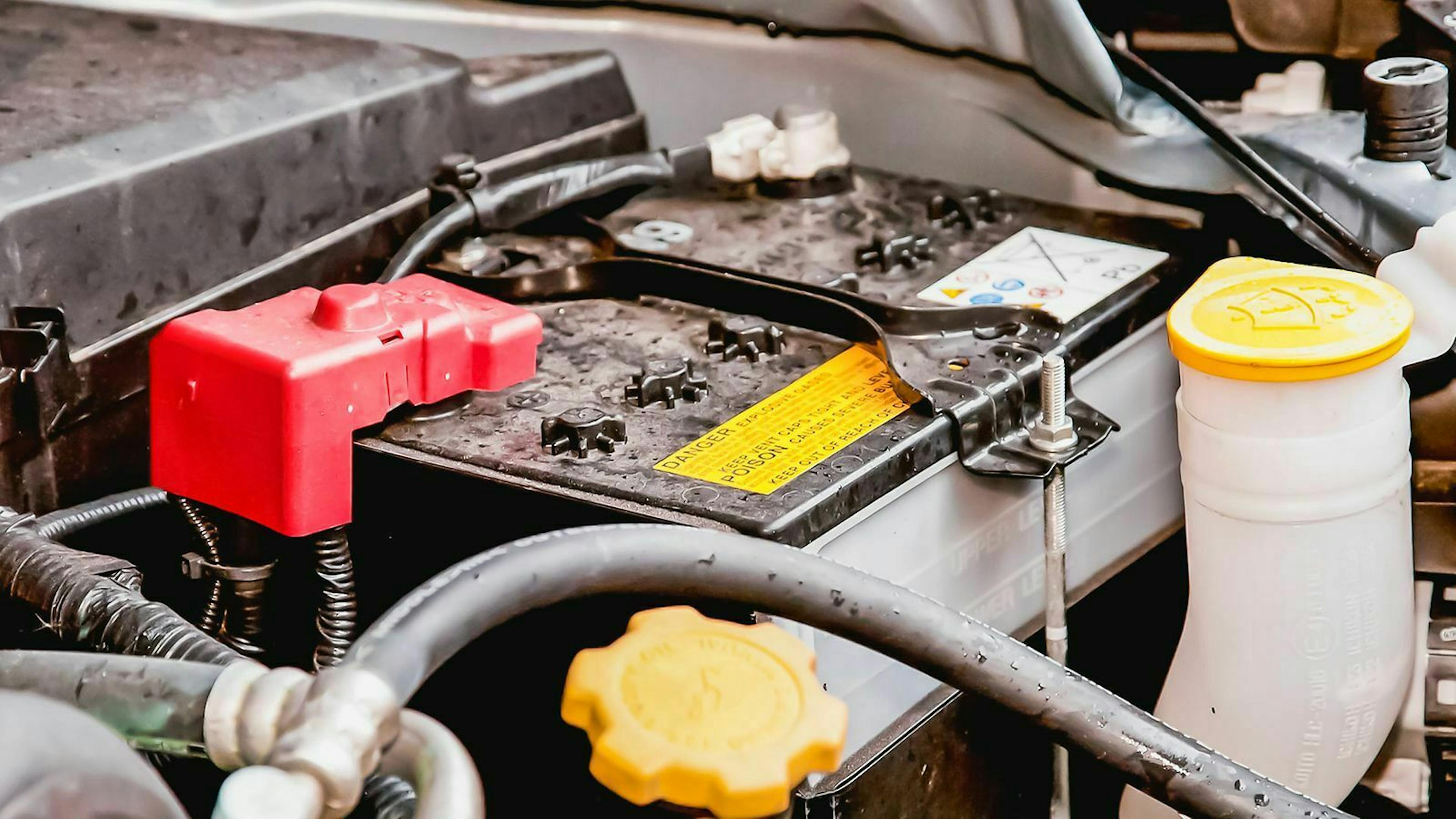 Im Motorraum eines Autos ist die Autobatterie montiert.