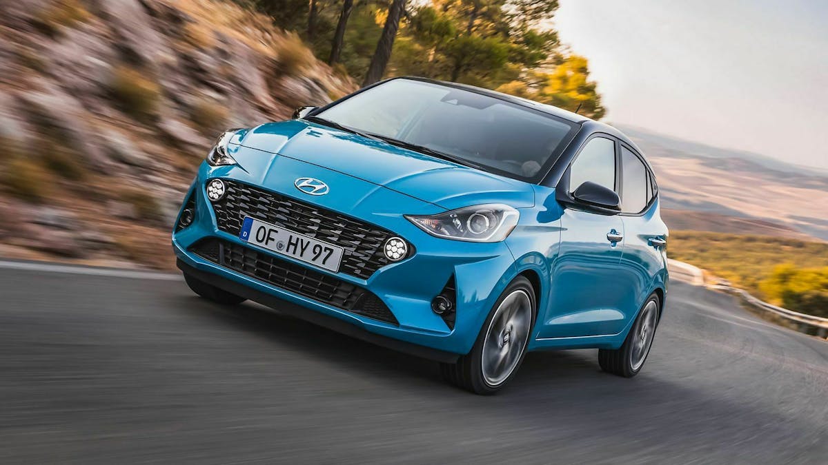 Ein hellblauer Hyundai i10 fährt über eine Landstraße