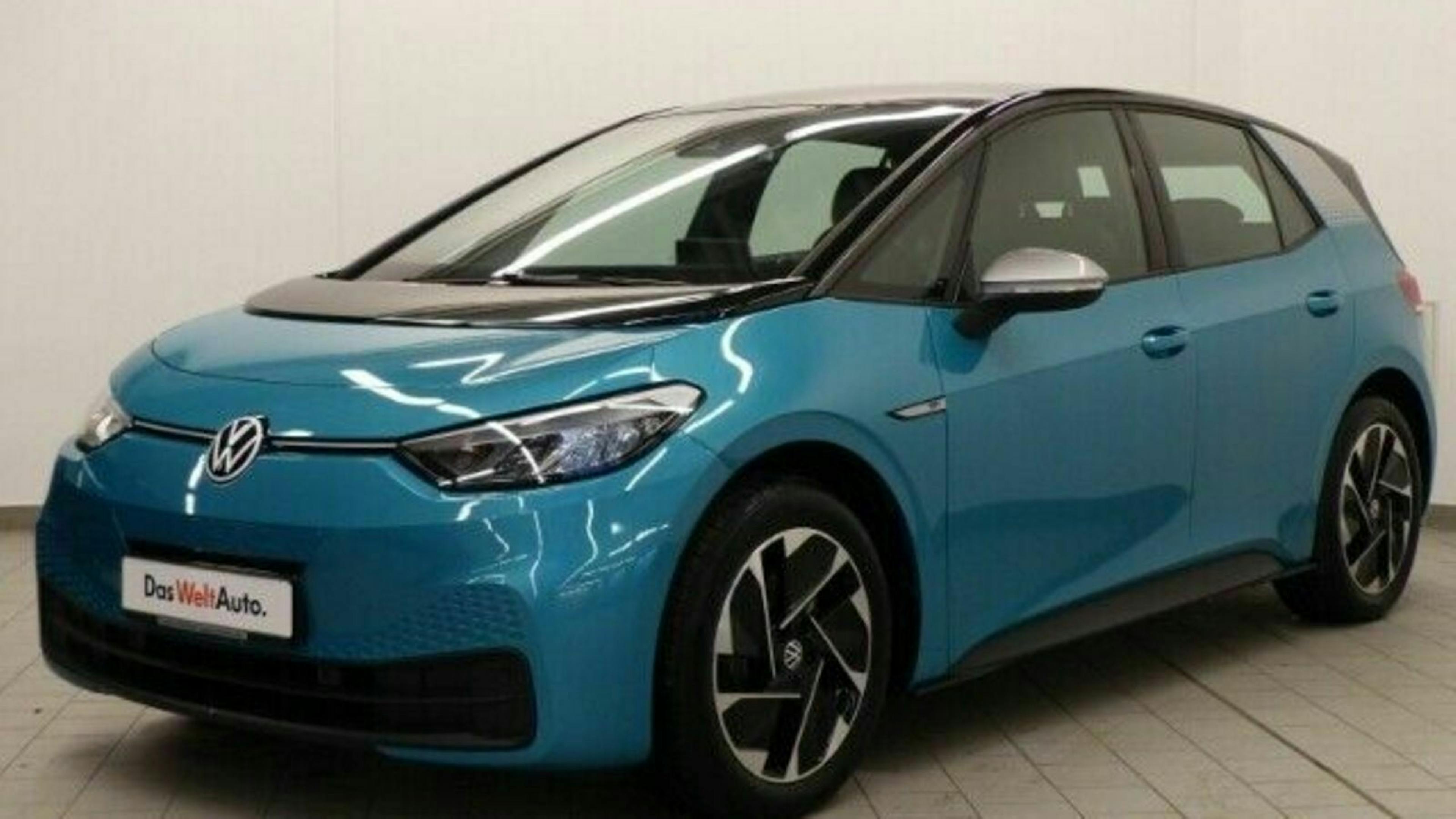 Ein türkisfarbener VW ID.3 mit Heckantrieb steht vor einer weißen Wand
